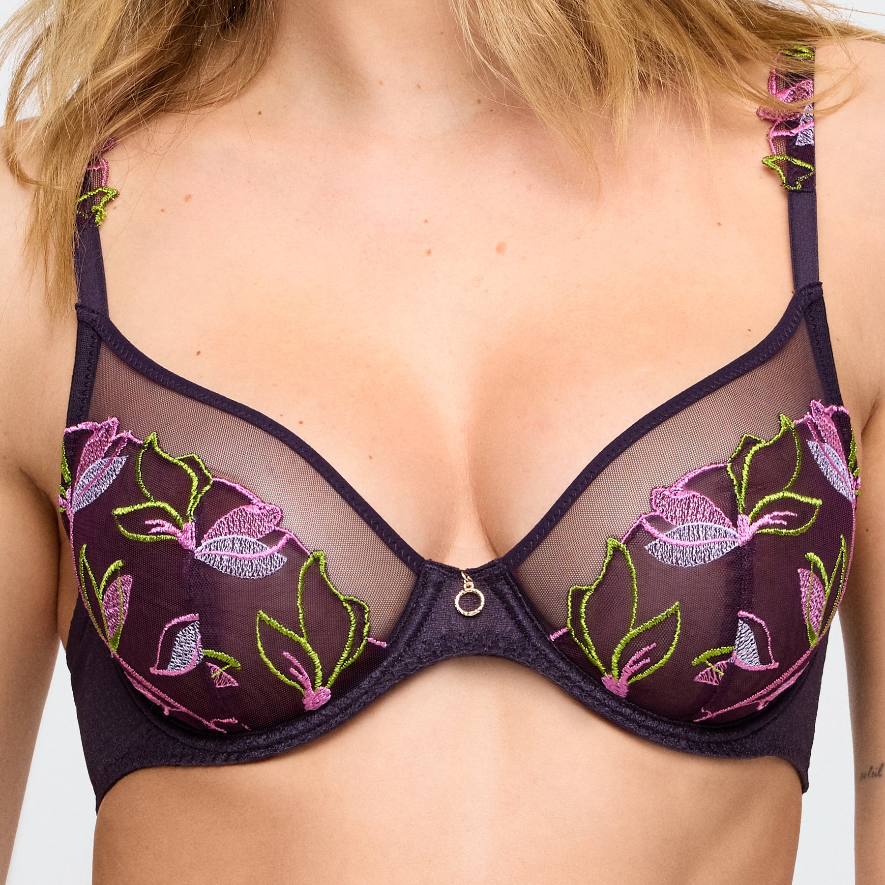 Zoomed-in view of floral embroidery on sheer mesh cups and centre gold ring detail of the plunge bra.