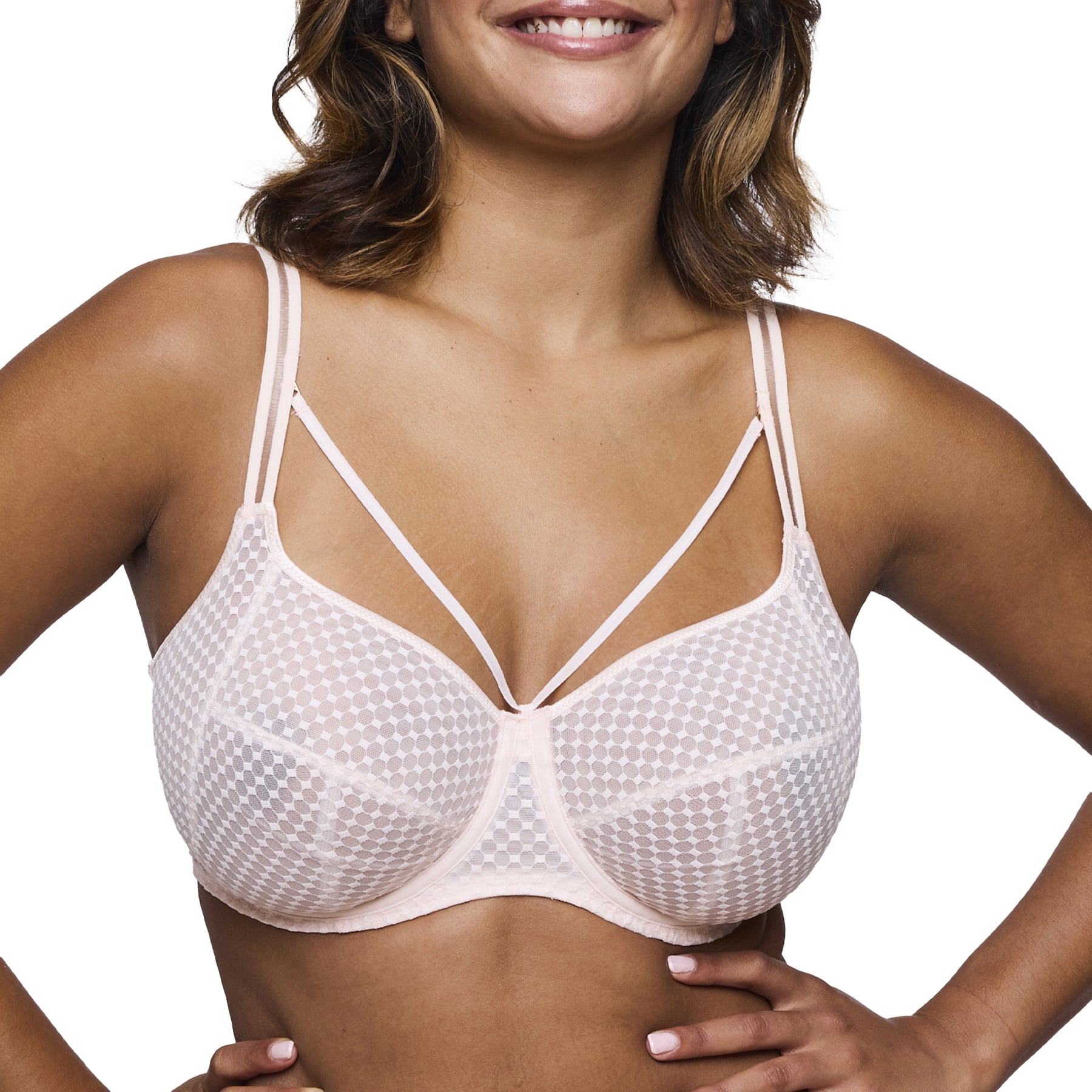 Close-up front view of a woman wearing the beige polka dot bra with double straps and strappy neckline.