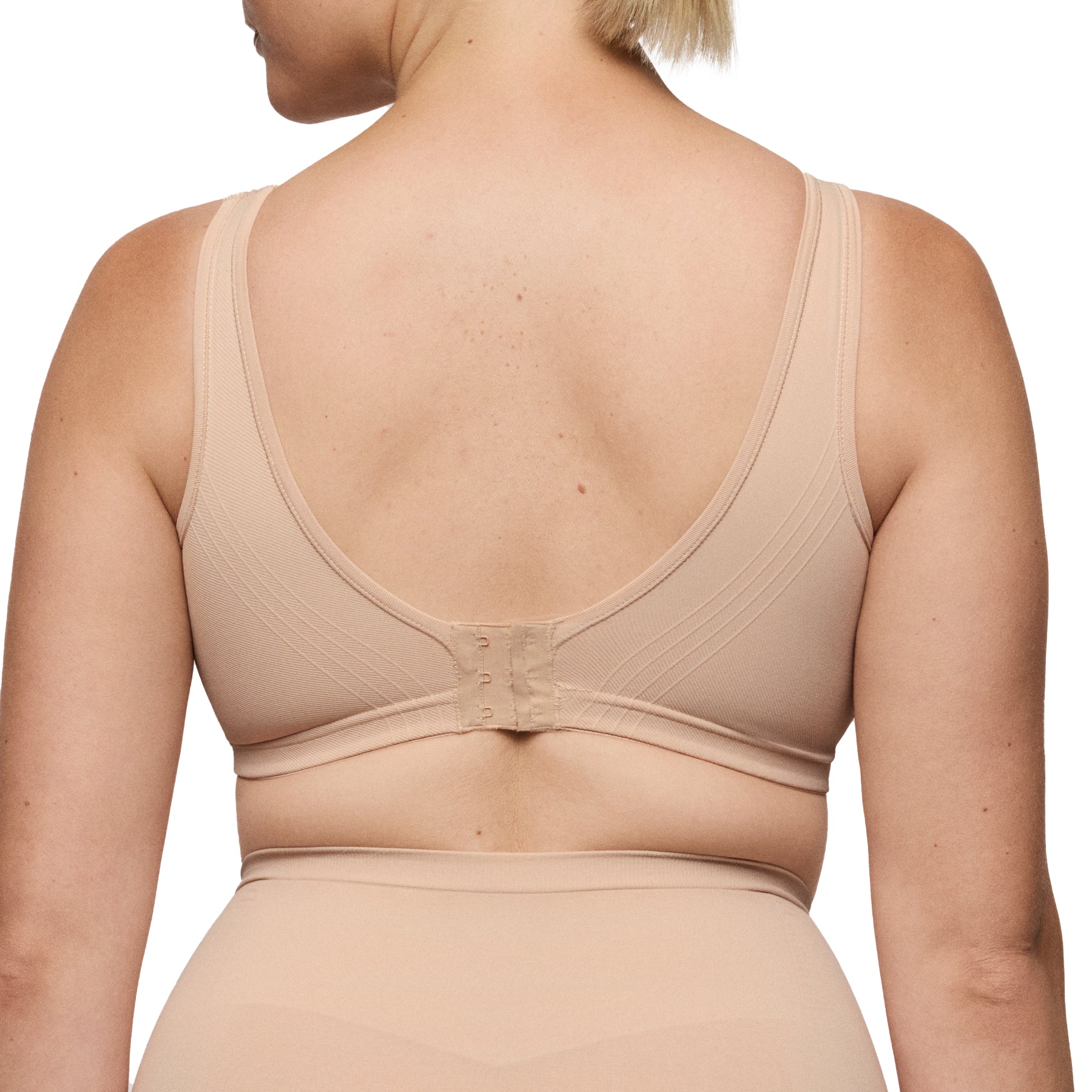 Back view of nude seamless wireless bra with hook-and-eye closure and wide smoothing straps