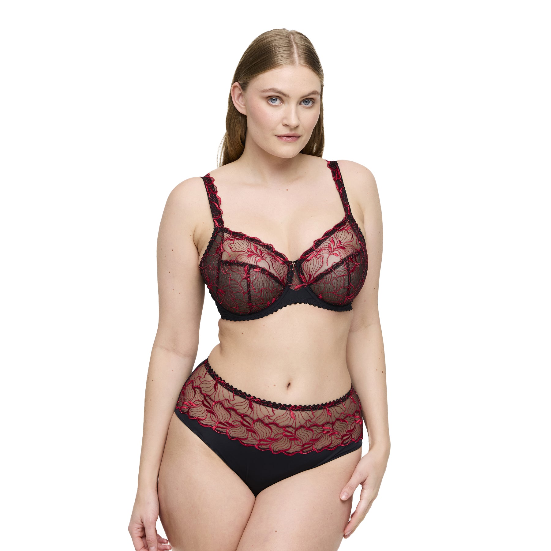 Woman wearing a red and black lace lingerie set on a white background