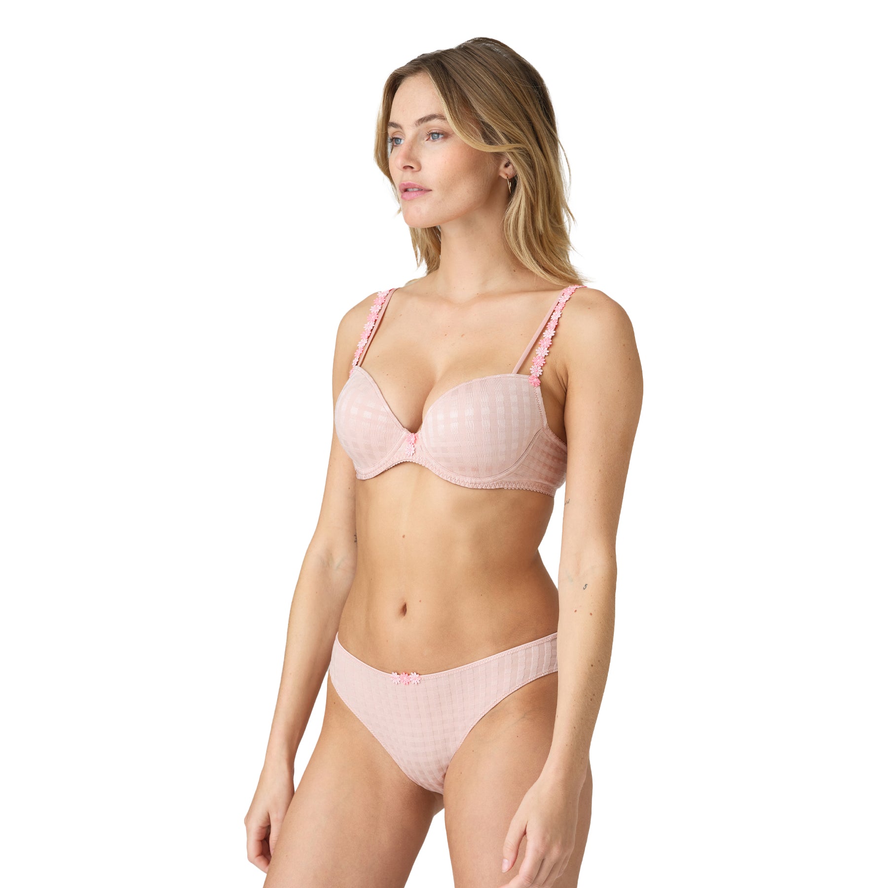 Woman wearing a pastel pink gingham lingerie set with floral strap details and low-rise bikini panties.