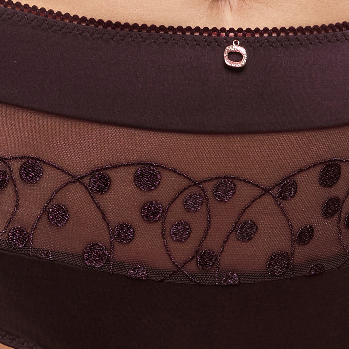 Close-up of amethyst purple high-waist panties with sheer embroidered mesh, dotted detailing and a gold charm.