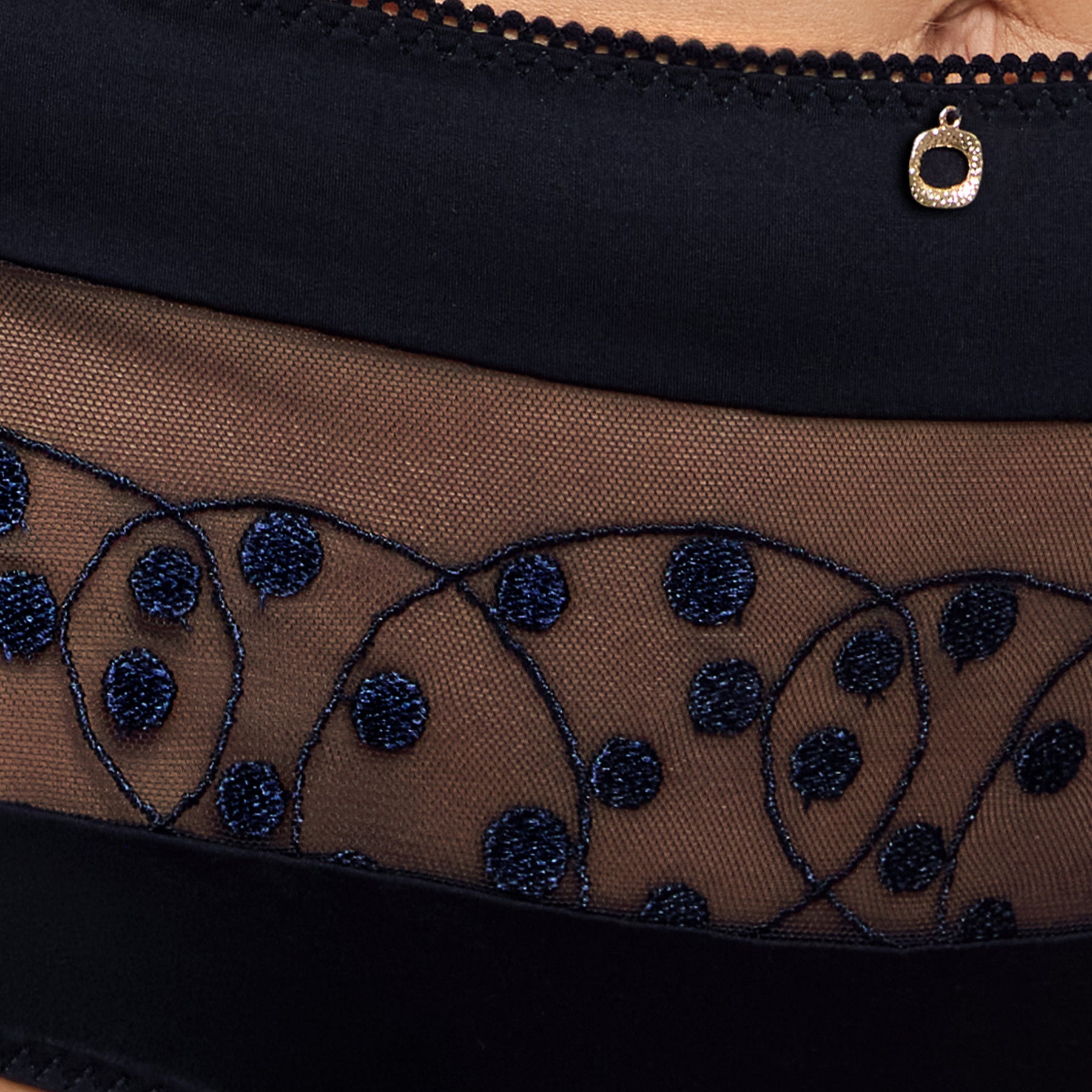 Close-up of Empreinte Tess embroidery featuring navy polka dot motifs on sheer tulle