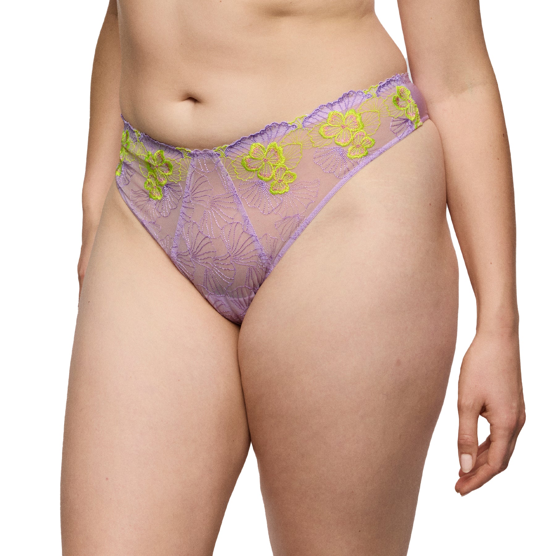 Model wearing wisteria lace thong with sheer lavender mesh and contrast neon floral embroidery.