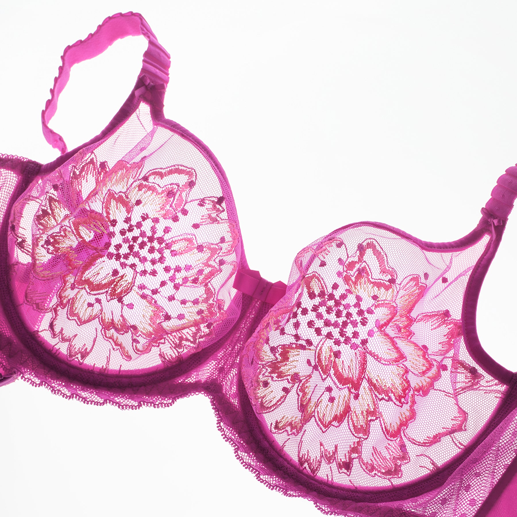 Fuchsia embroidered underwire bra laid flat, showcasing large floral motif on sheer mesh cups.