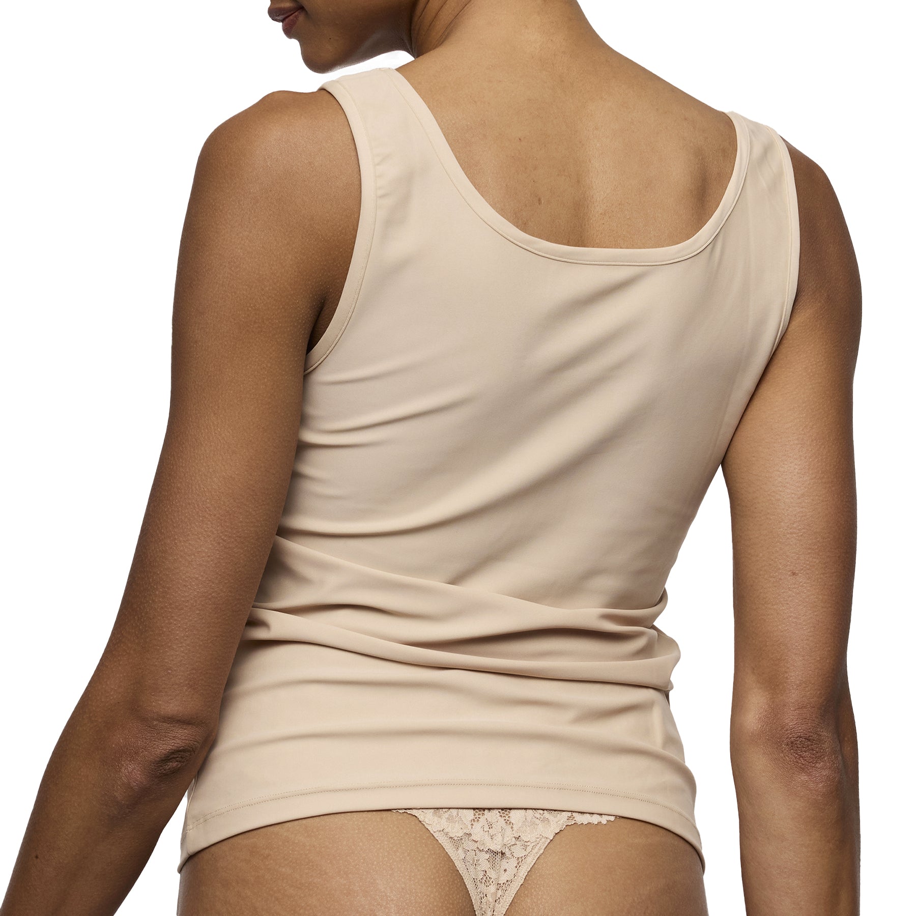 Nude seamless tank top with wide straps and smooth stretch fabric back worn with lace thong