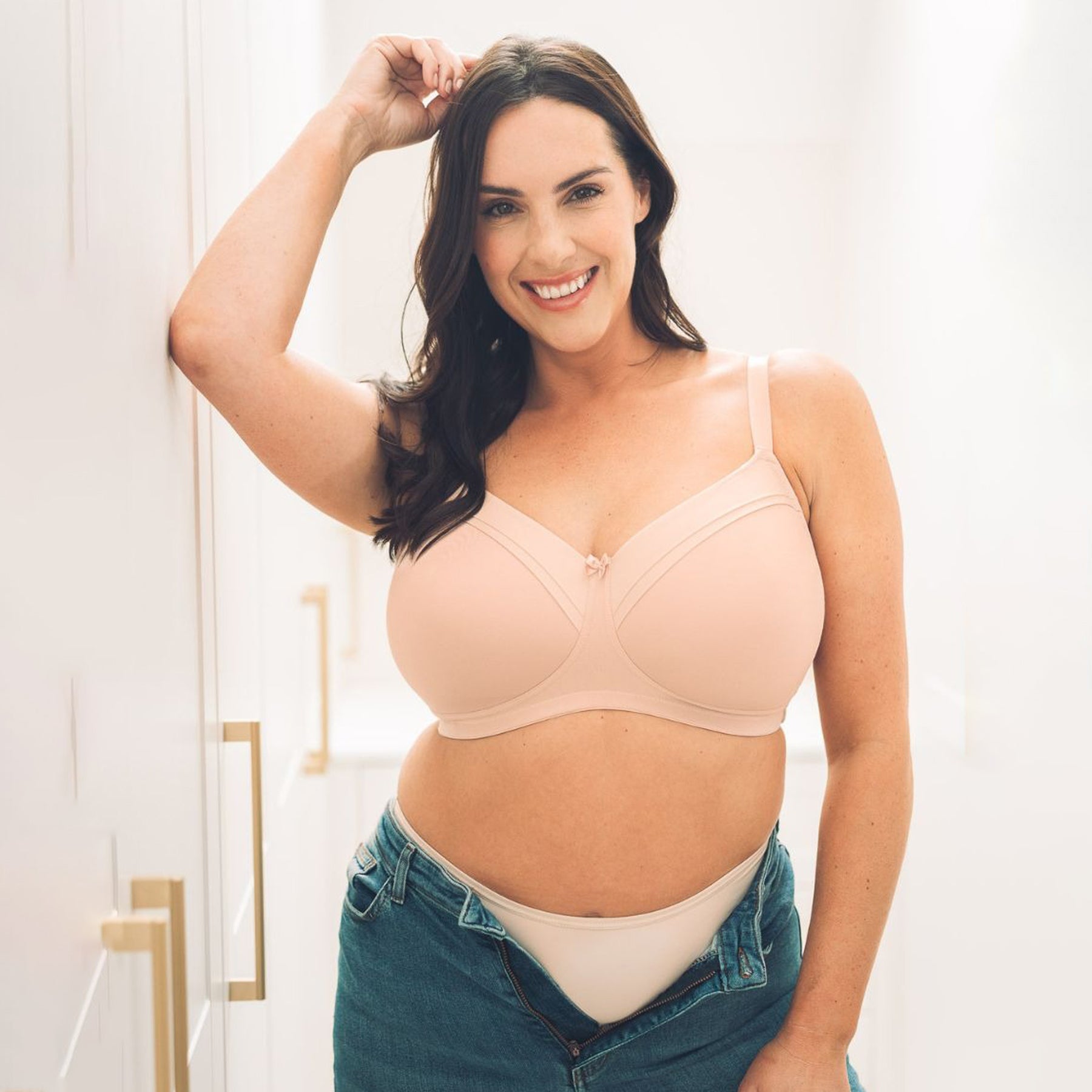 Blush pink bra with adjustable straps and hook-and-eye closure.