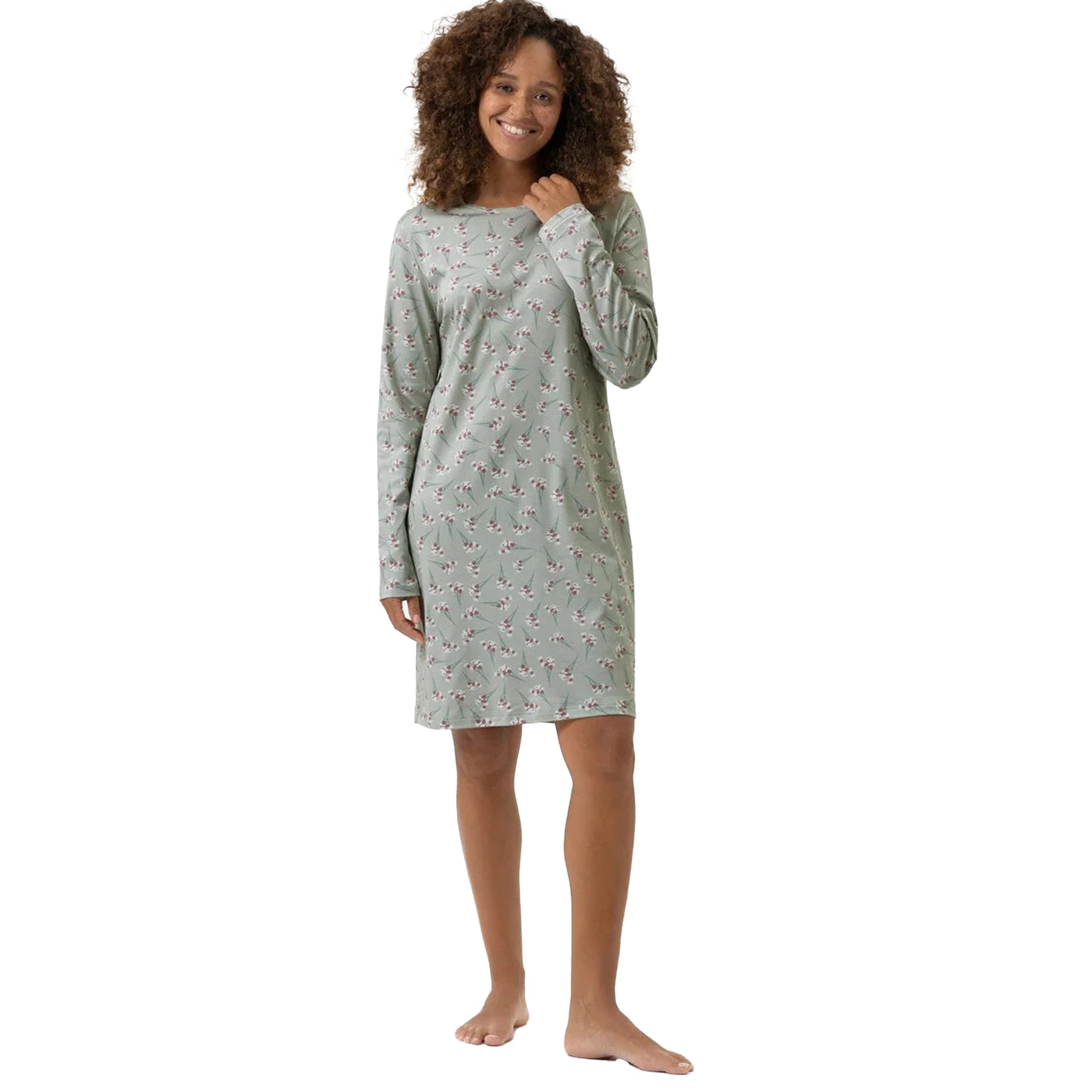 Woman wearing a sage green floral long-sleeve nightshirt, smiling with relaxed fit.