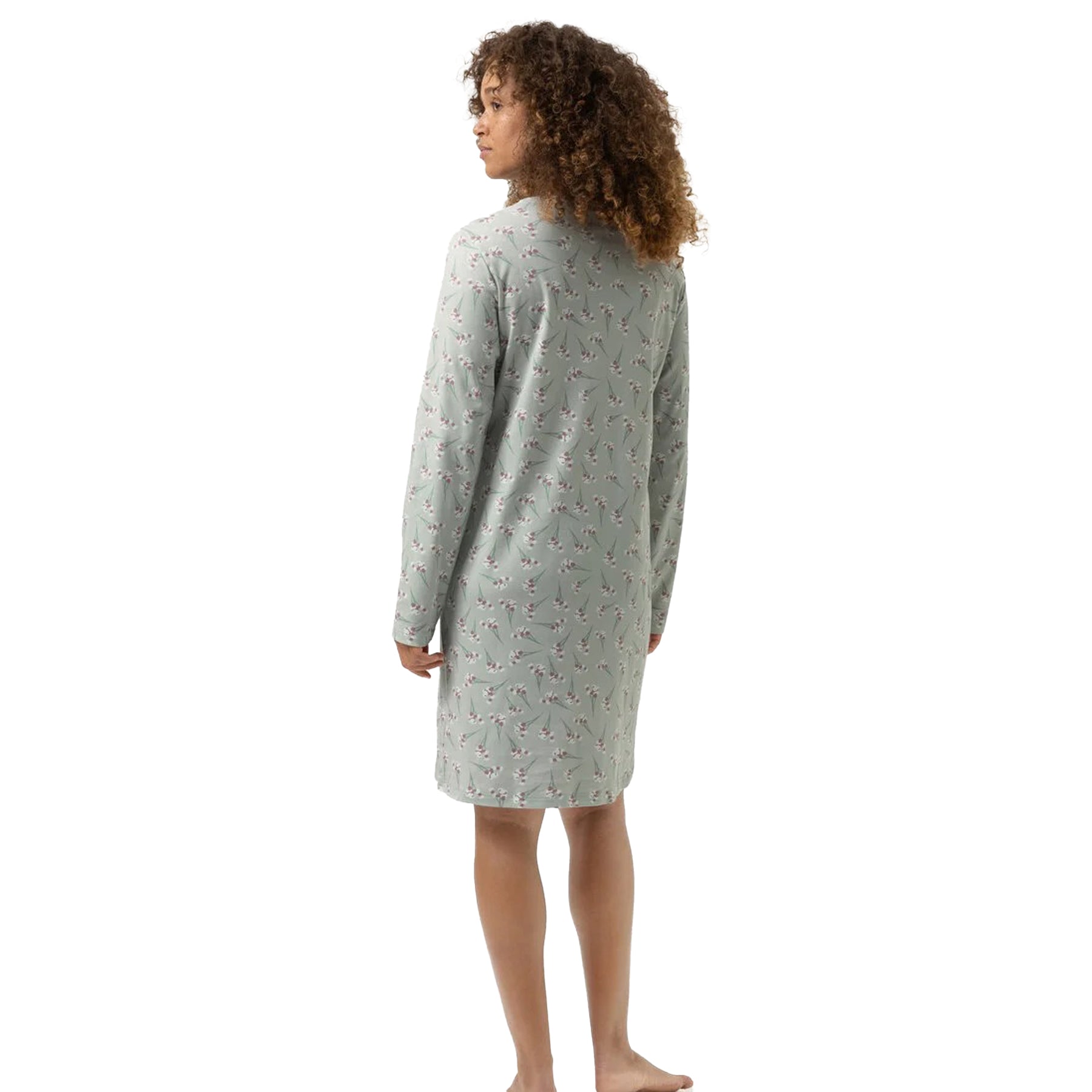 Woman in sage green floral nightshirt showing full back design and long sleeves.