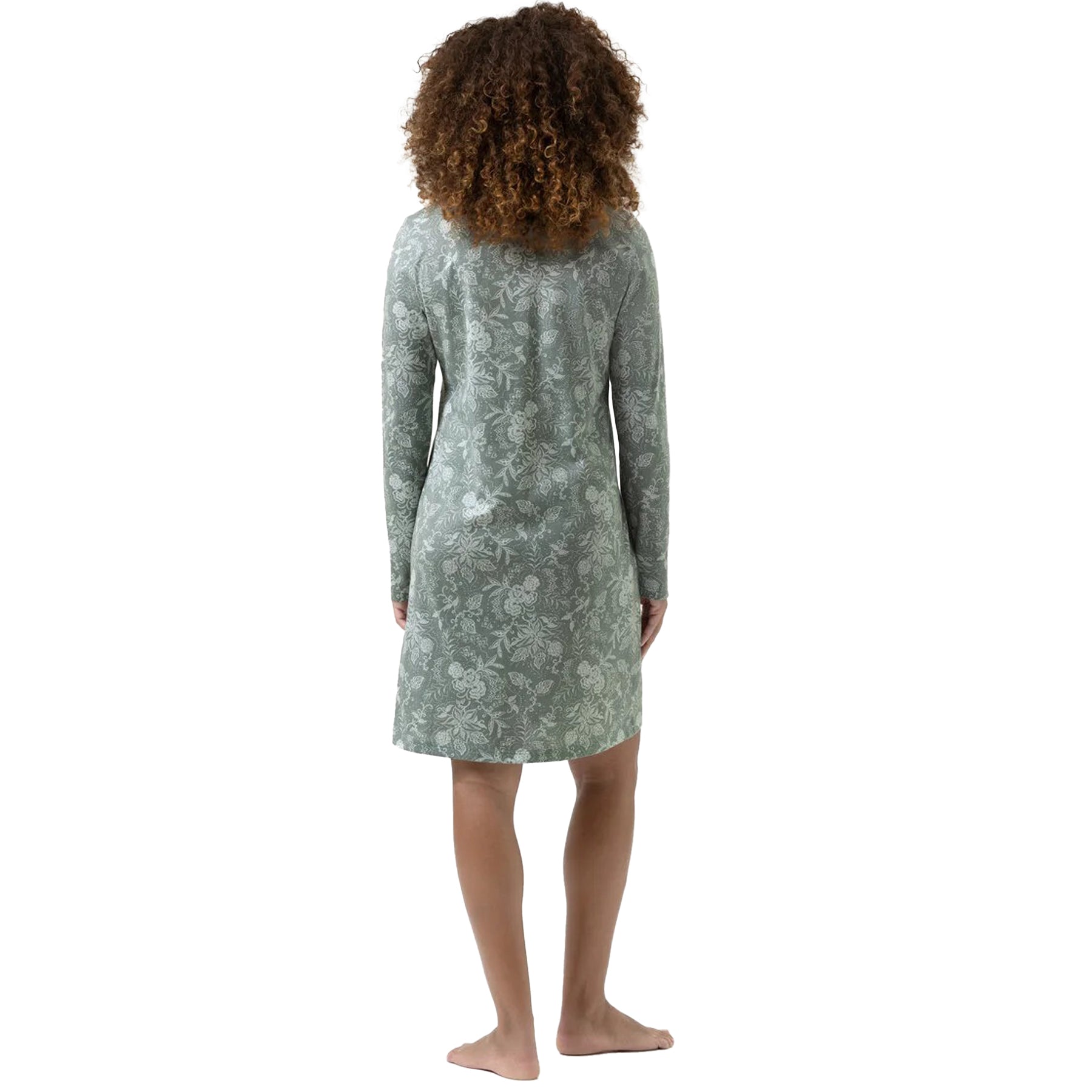 Woman showing the back of a sage green long-sleeve nightshirt with white floral design.