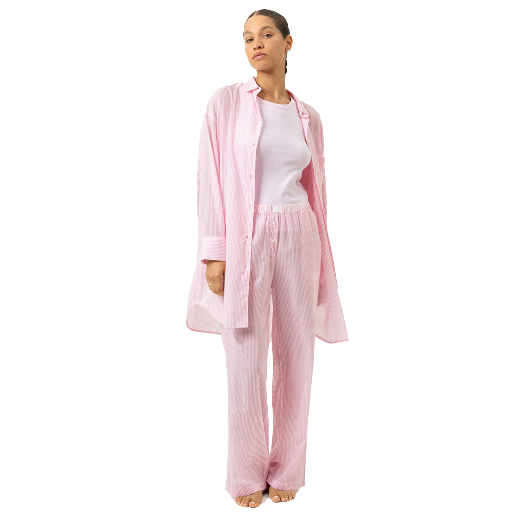 Woman wearing pink striped nightshirt styled with matching striped lounge pants