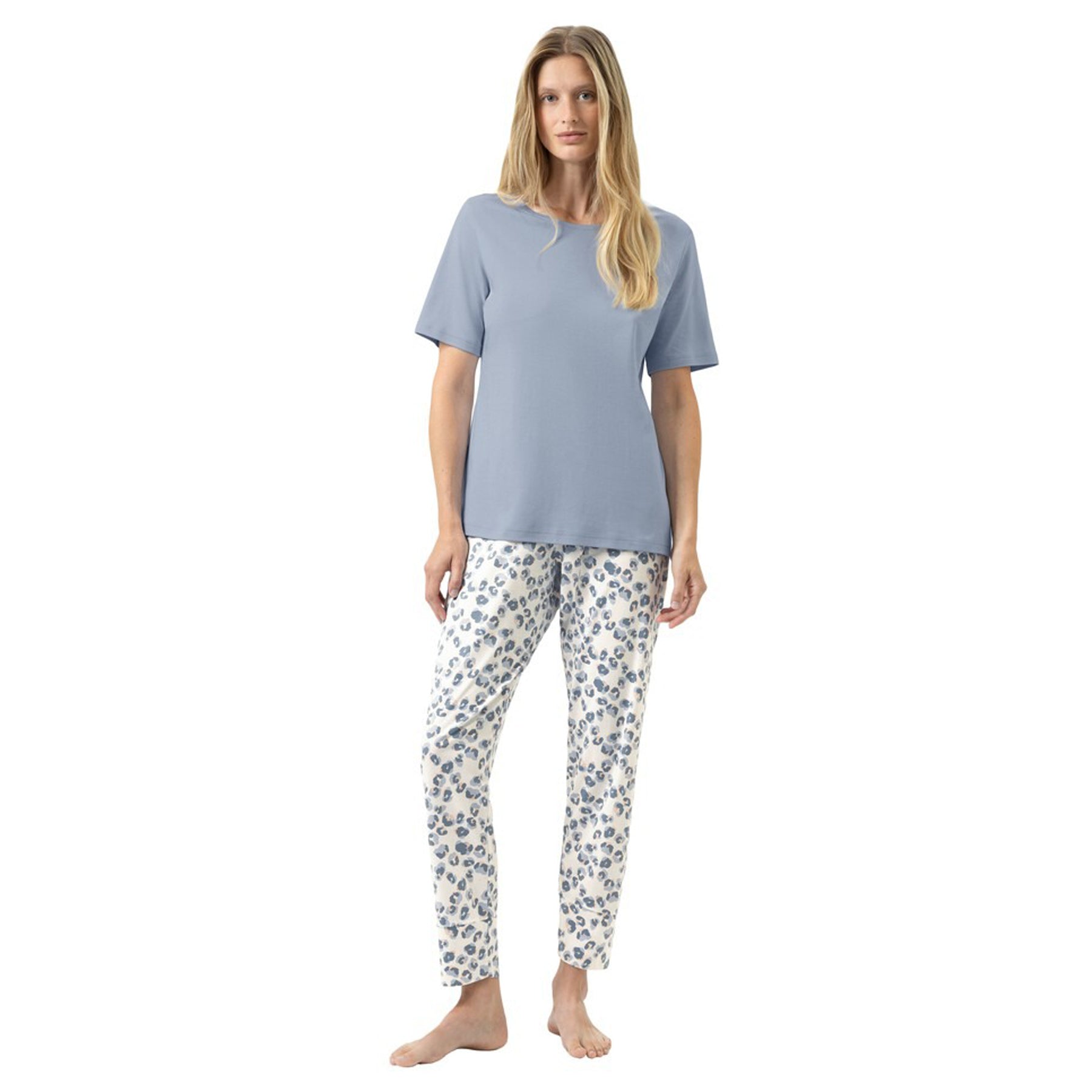 Woman wearing a short-sleeve blue-grey T-shirt with matching printed lounge pants, relaxed fit pyjama set, front view on a white background.