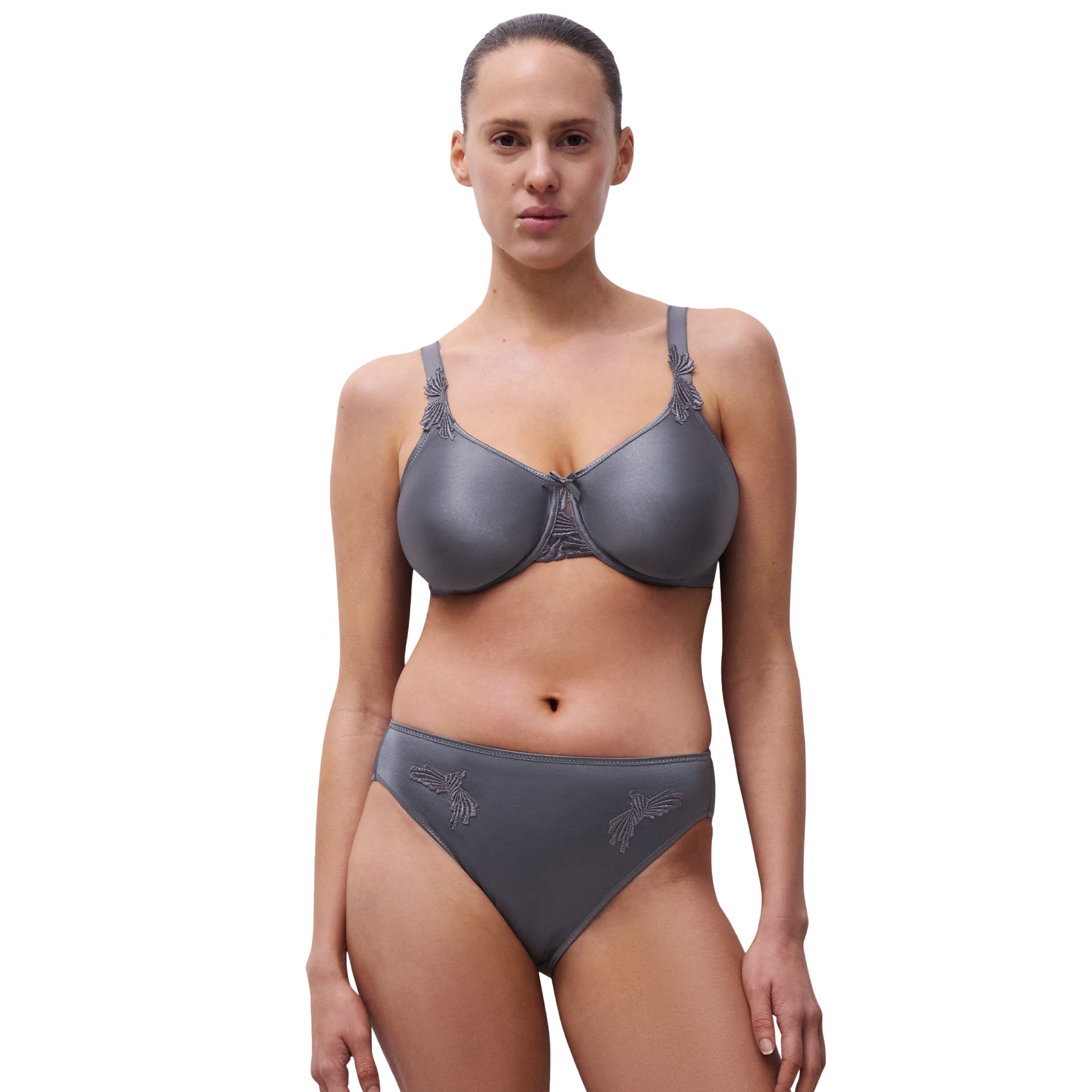 Model wearing seamless slate grey bra and high-cut brief with embroidered detailing, front view.