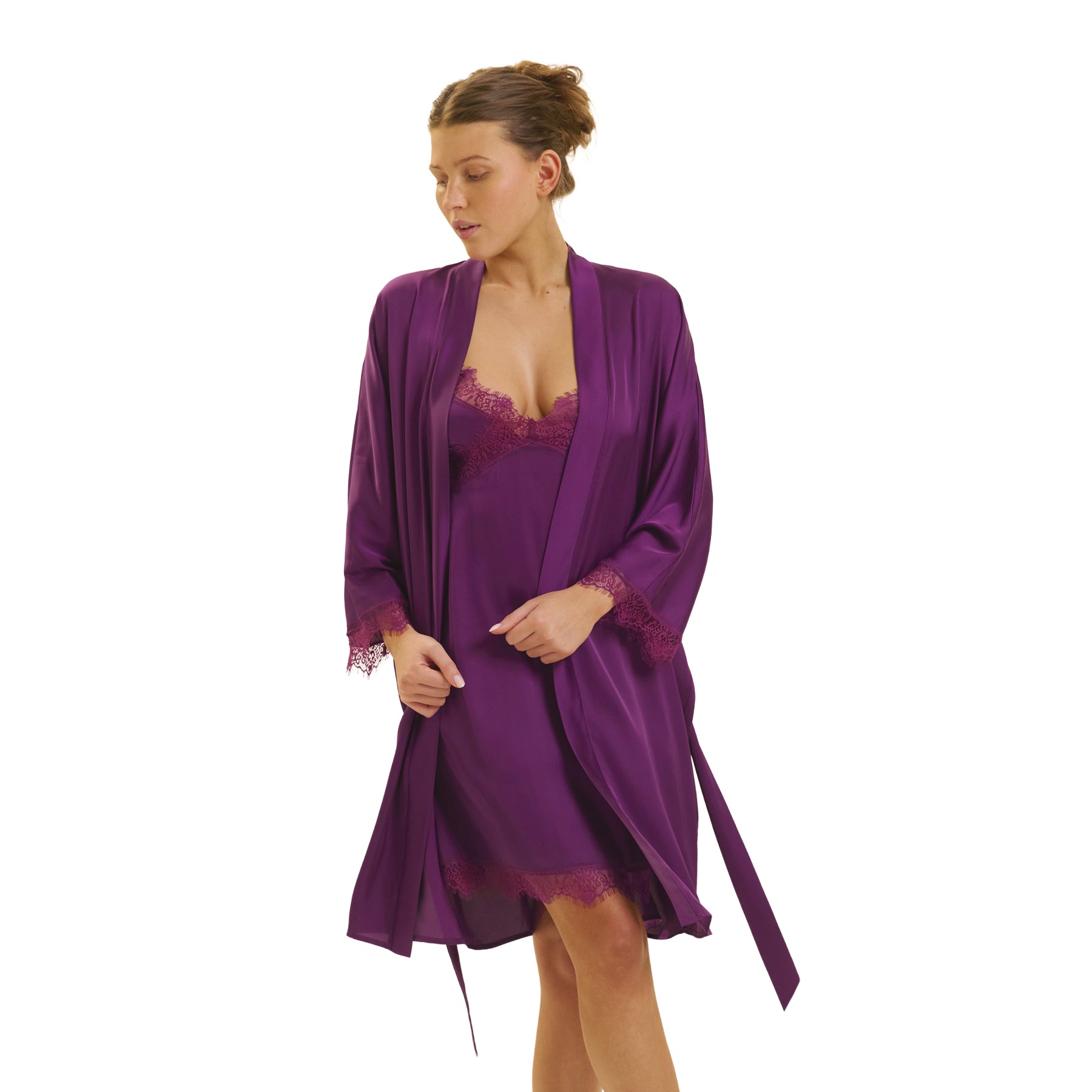 Woman wearing an open Simone Pérèle purple satin robe with lace cuffs over a matching lace-trimmed chemise.