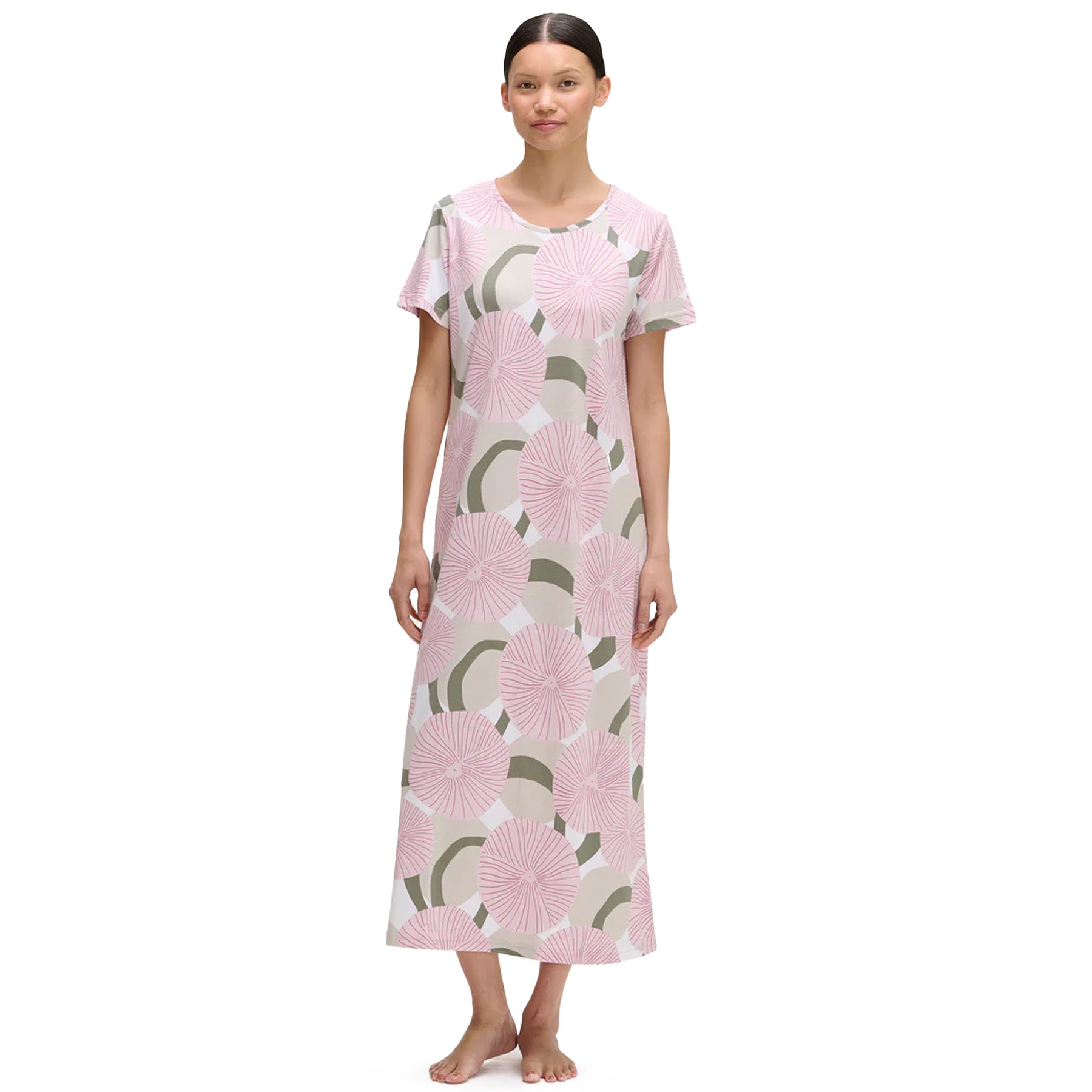 Woman wearing a long pink and sage green circular floral print nightgown with short sleeves and round neckline.