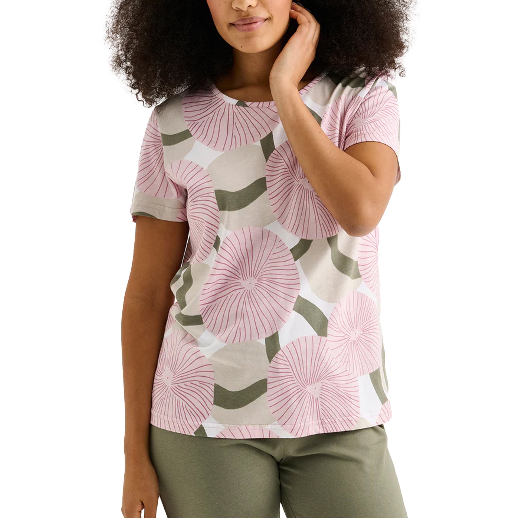 Close-up of pink circular floral print short-sleeve pajama top paired with sage green elastic waist pants on model.
