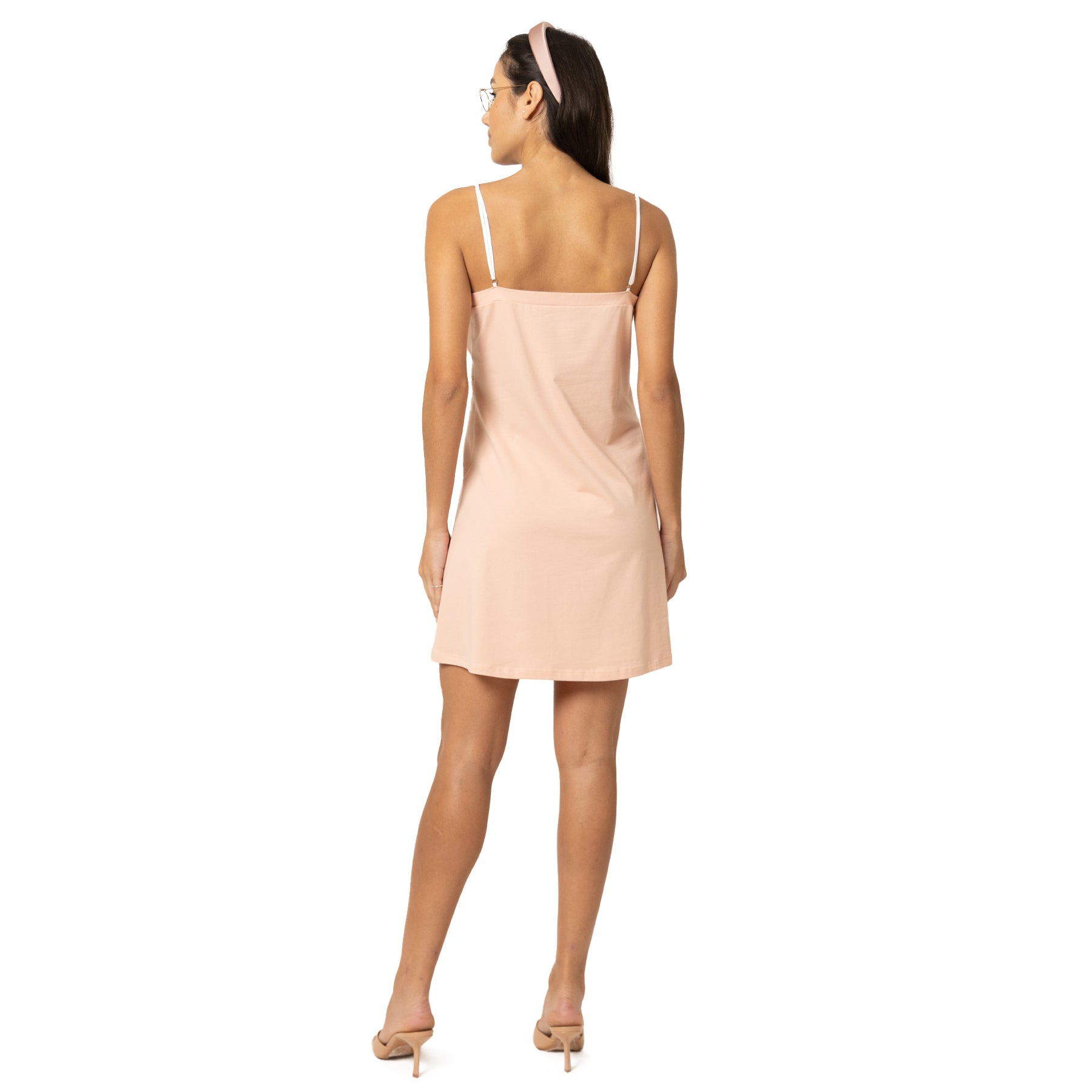 Back view of blush pink slip nightdress with thin straps and smooth, minimalist silhouette