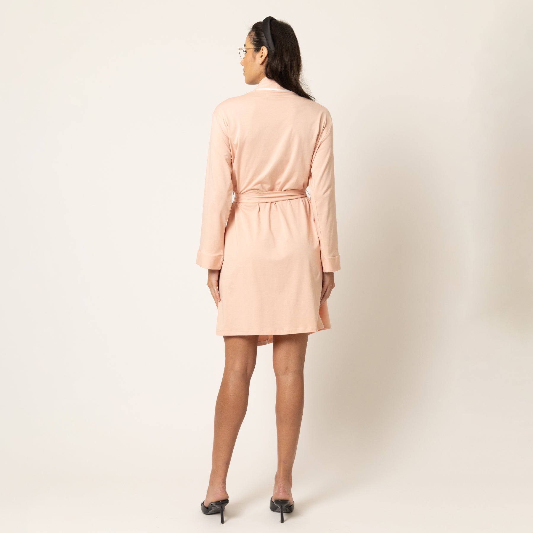 Soft blush pink wrap robe with white piping detail and waist tie, long sleeves, front view