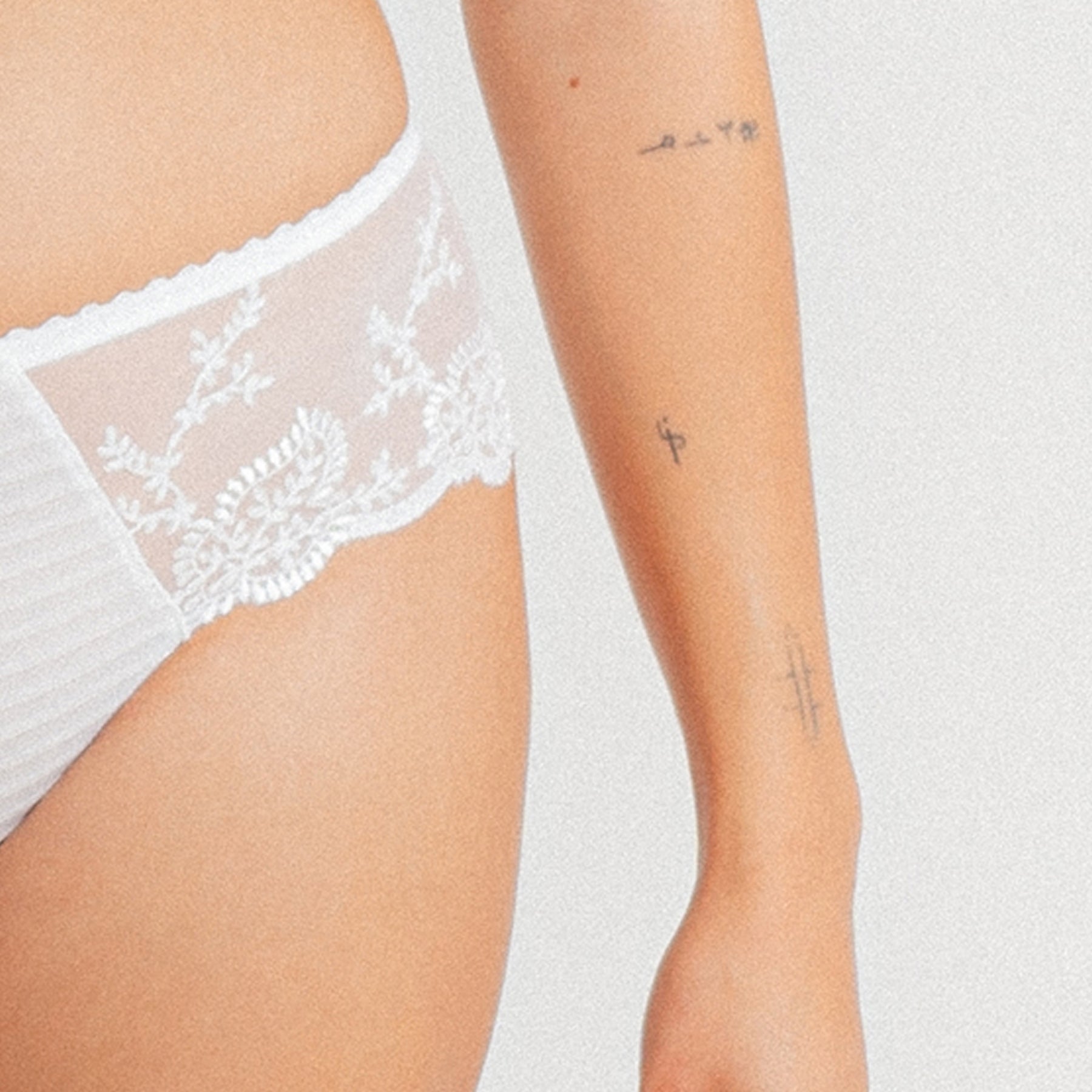 Close-up of Louisa Bracq Elise Shorty in White - side mesh detail with floral embroidery and soft waistband