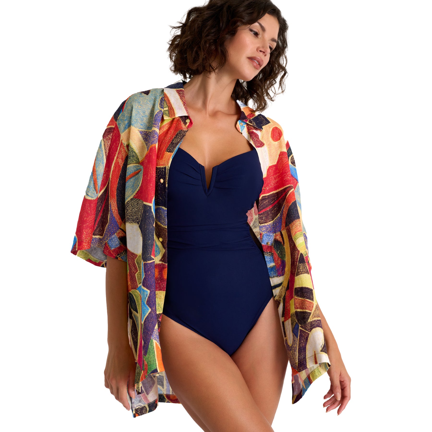 Woman wearing a navy swimsuit with a colorful kimono-style cover-up on a white background