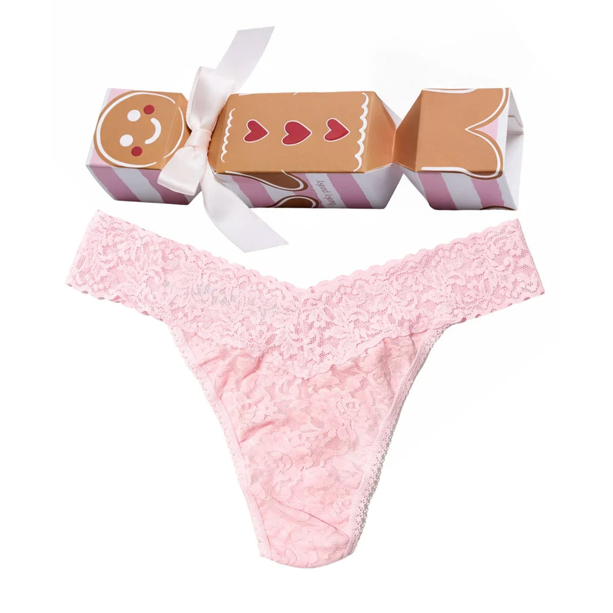 Hanky Panky Signature Lace Original Rise Thong in Bliss Pink, featuring delicate floral lace and a scalloped waistband, displayed with festive gingerbread cracker gift packaging.