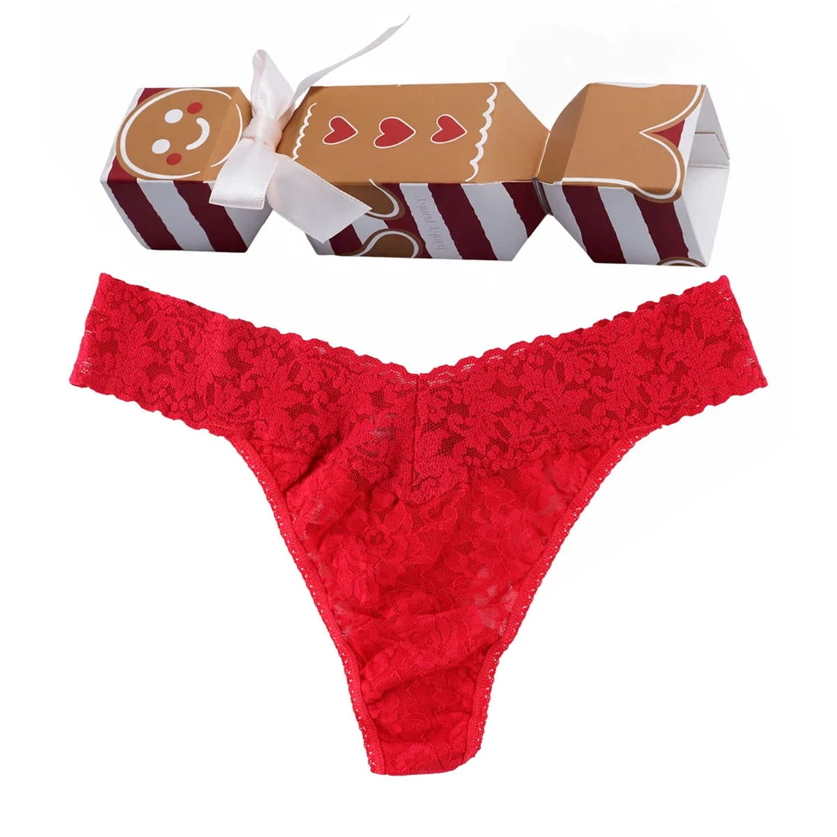 Hanky Panky Signature Lace Original Rise Thong in festive red, featuring floral lace and a scalloped waistband, displayed with gingerbread-themed holiday cracker gift packaging.