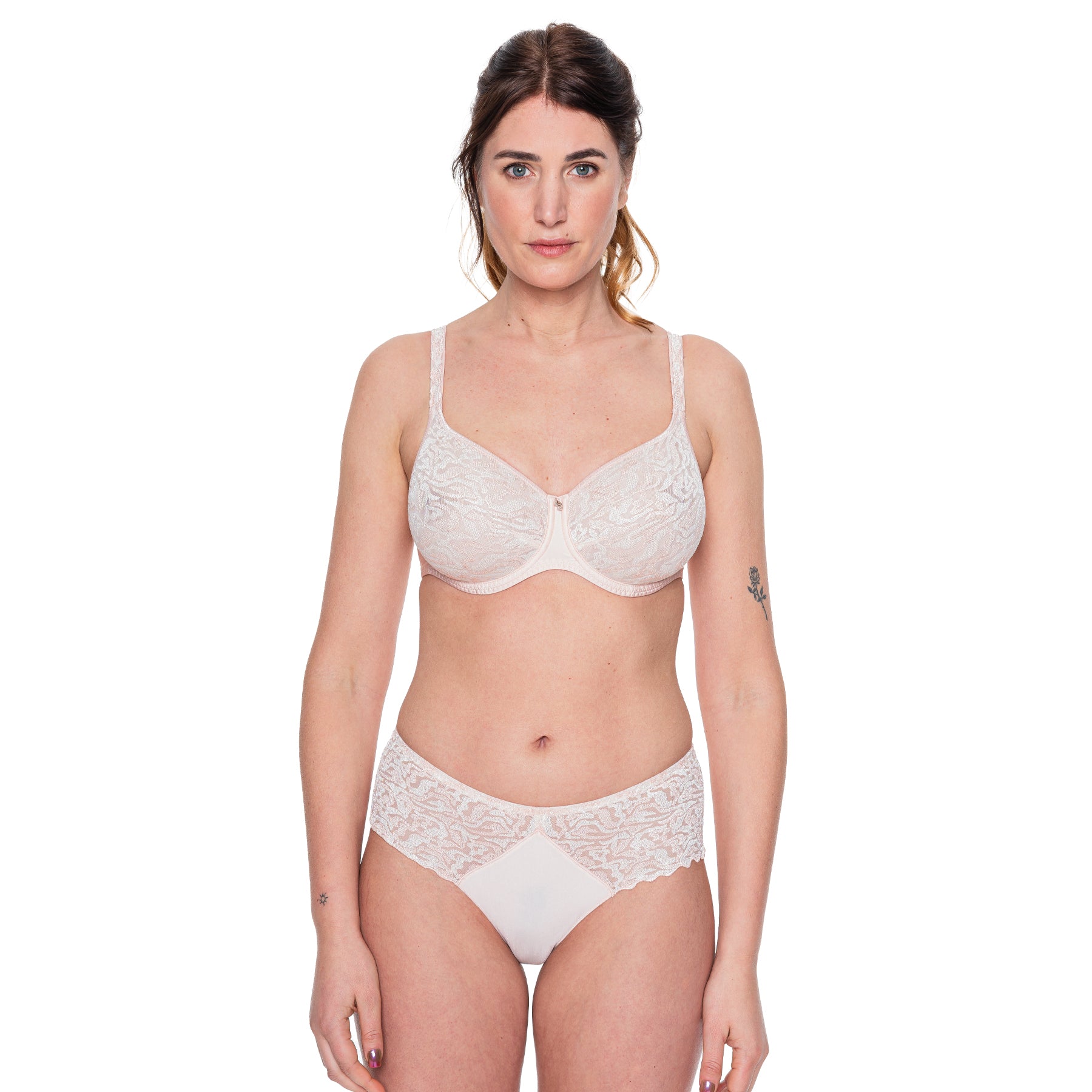 Full body view of model wearing matching nude rose lace bra and high-waist brief set with sheer floral detailing.