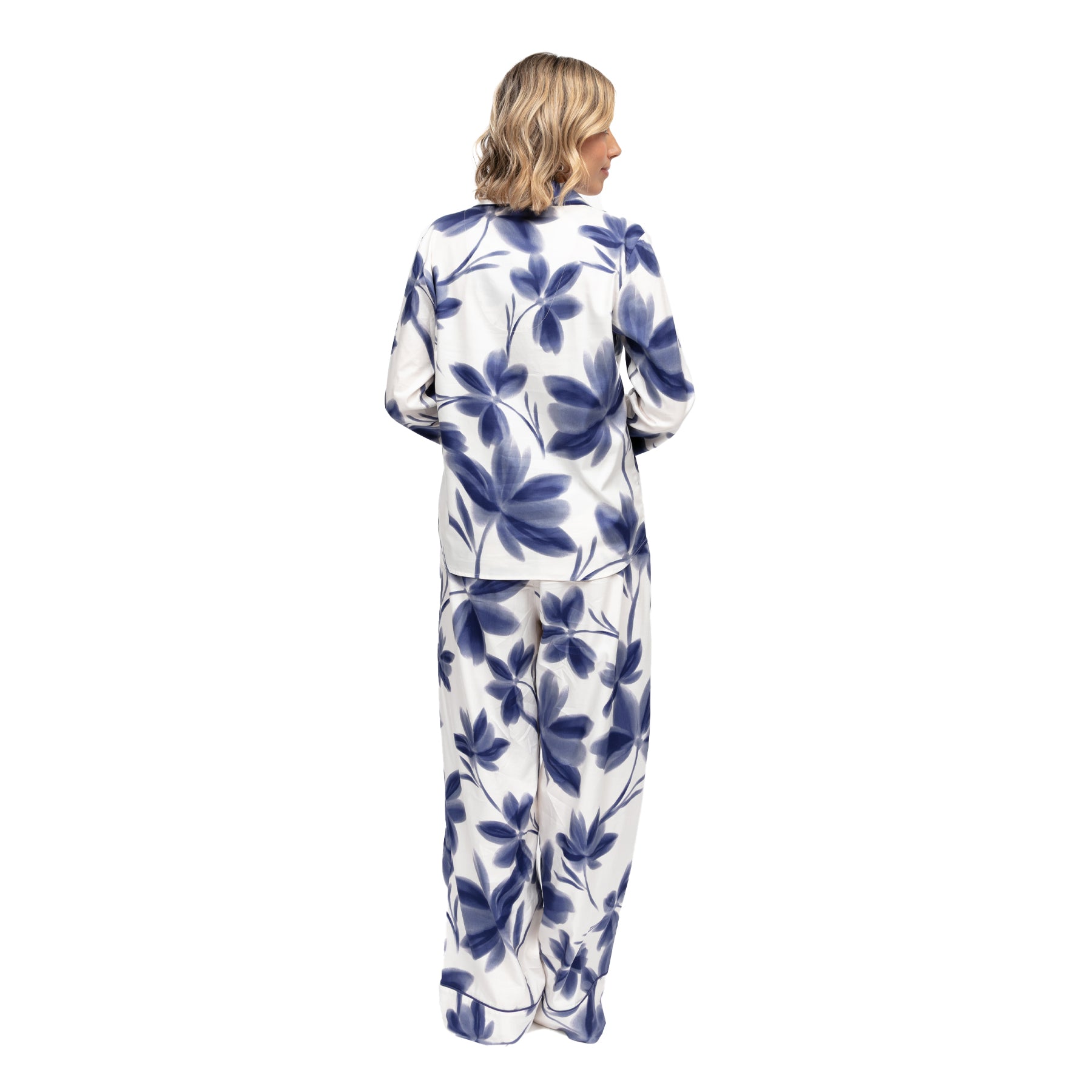 Close-up detail of white pyjama top with large navy floral print, classic collar and blue button accents.