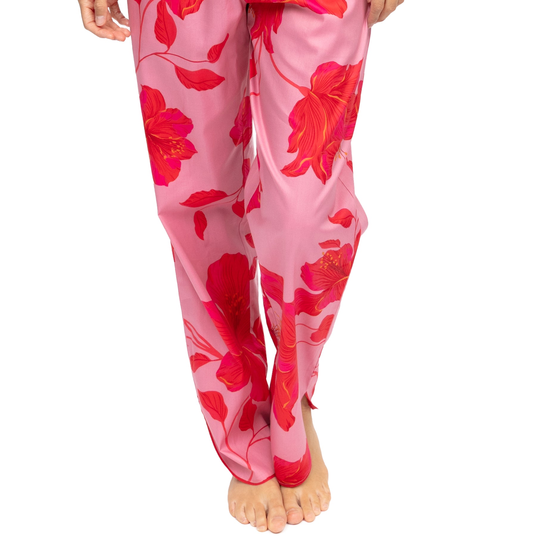 Close-up of pink floral pajama pants with wide-leg fit and bold hibiscus pattern