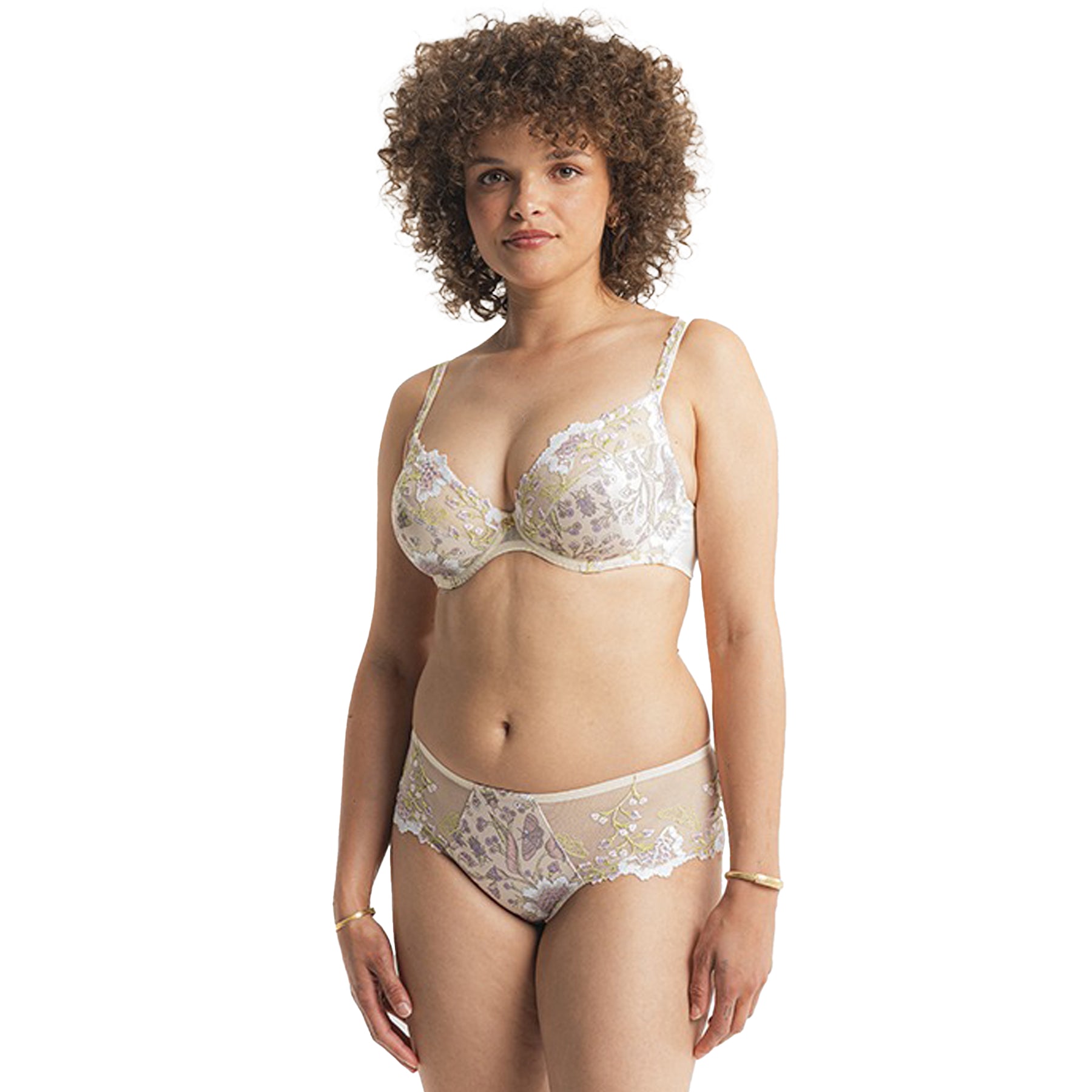 Front view of a woman wearing matching floral embroidered bra and panty set in beige and pastel tones.