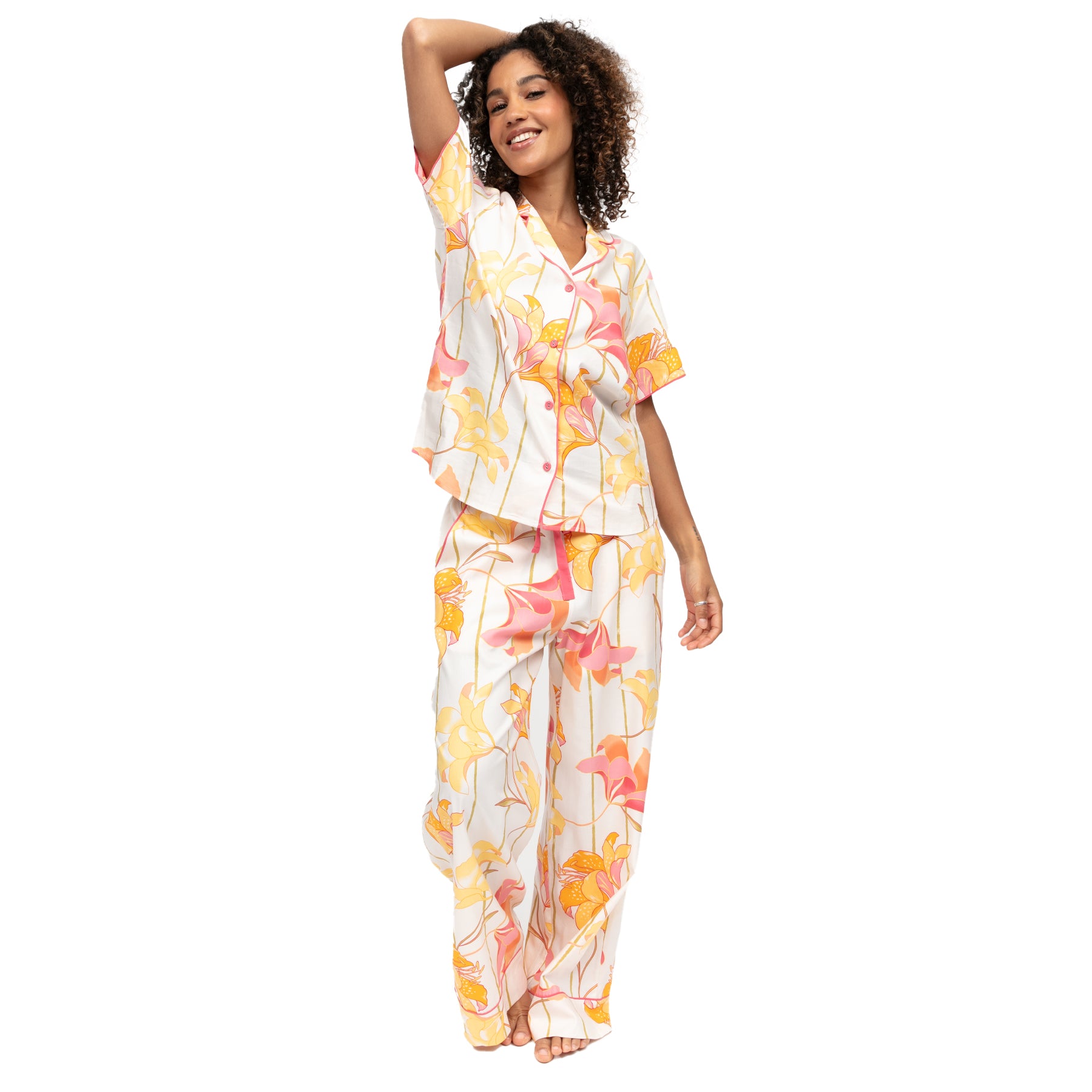 Women’s floral pyjama set with short sleeve button-up top and wide-leg pants in soft white with yellow and coral lily print