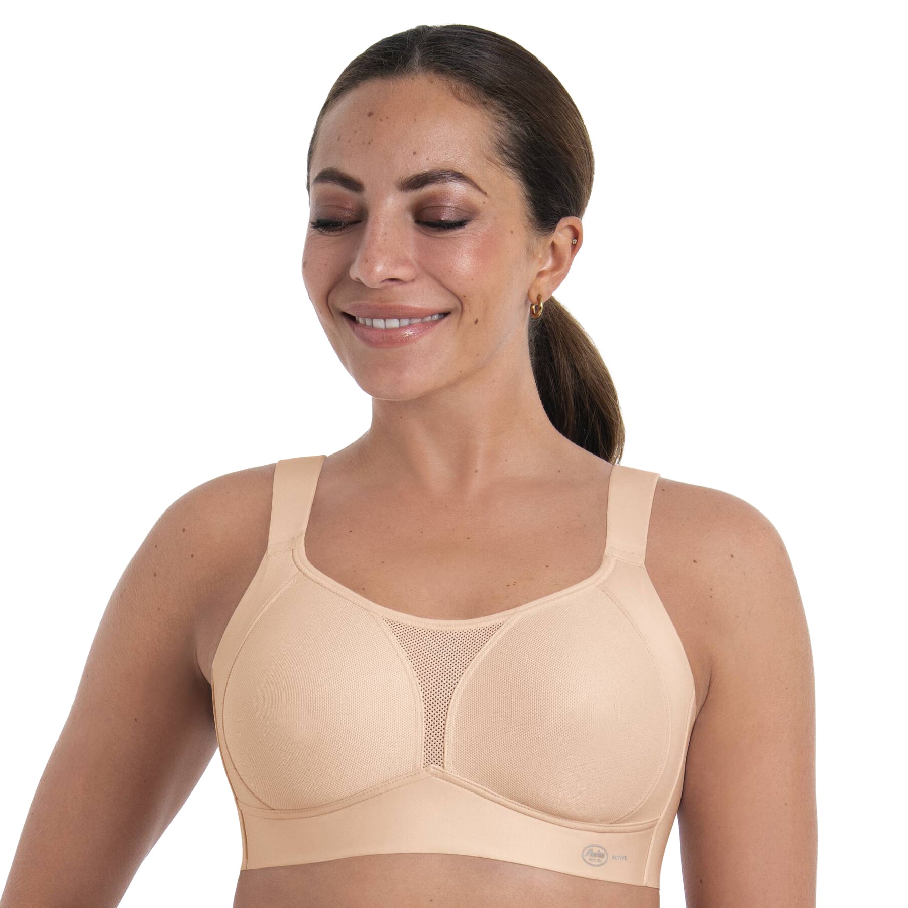 Woman wearing beige wireless sports bra with full coverage cups, breathable mesh panel and smooth support design