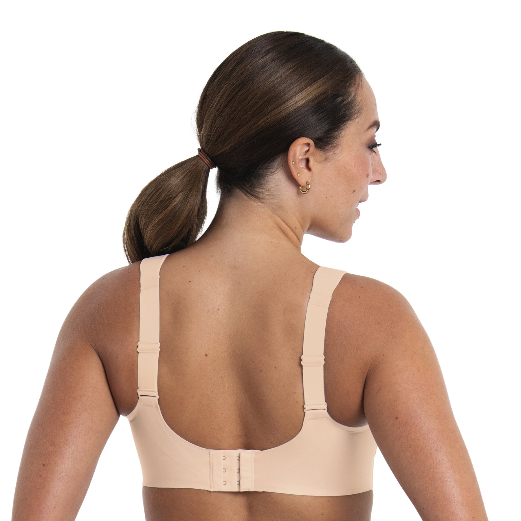 Back view of beige sports bra on model featuring wide straps, adjustable fit and supportive band