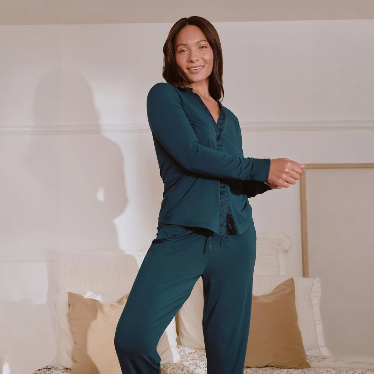Model wearing Fleurt pajama set in Deep Spruce teal, featuring a long-sleeve button-front top and matching pants, lifestyle view.