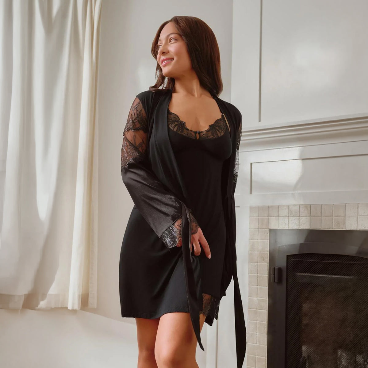 Model wearing Fleurt Desire Kimono in black over a matching lace-trimmed chemise, lifestyle front view.