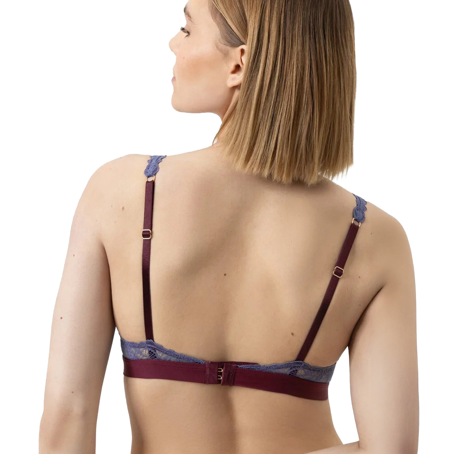 Model wearing burgundy bralette with blue lace overlay and matching briefs, styled with faux fur jacket