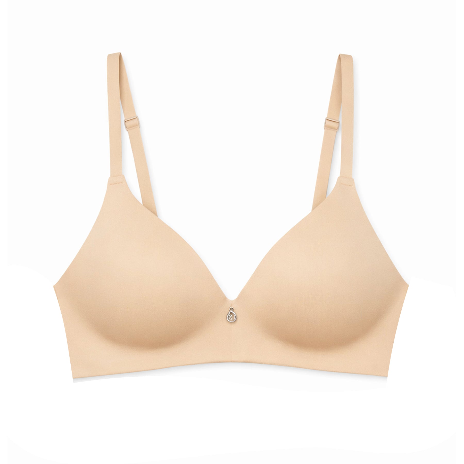 Flat lay of the sand seamless wireless bra on a white background, featuring moulded cups, adjustable straps, and centre charm detail.