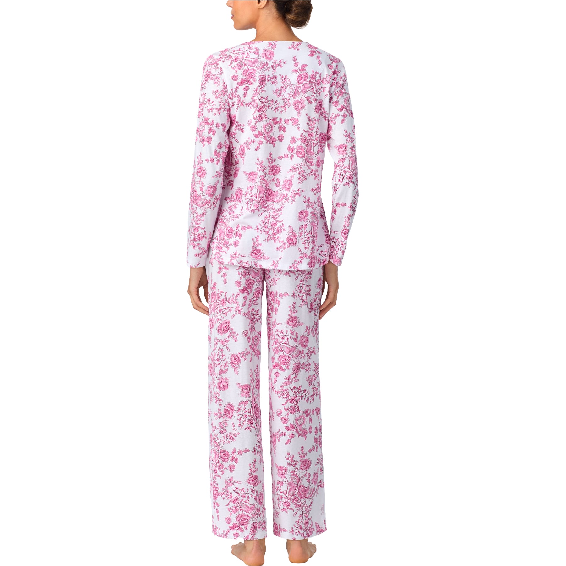 Woman wearing a pink floral pajama set on a white background