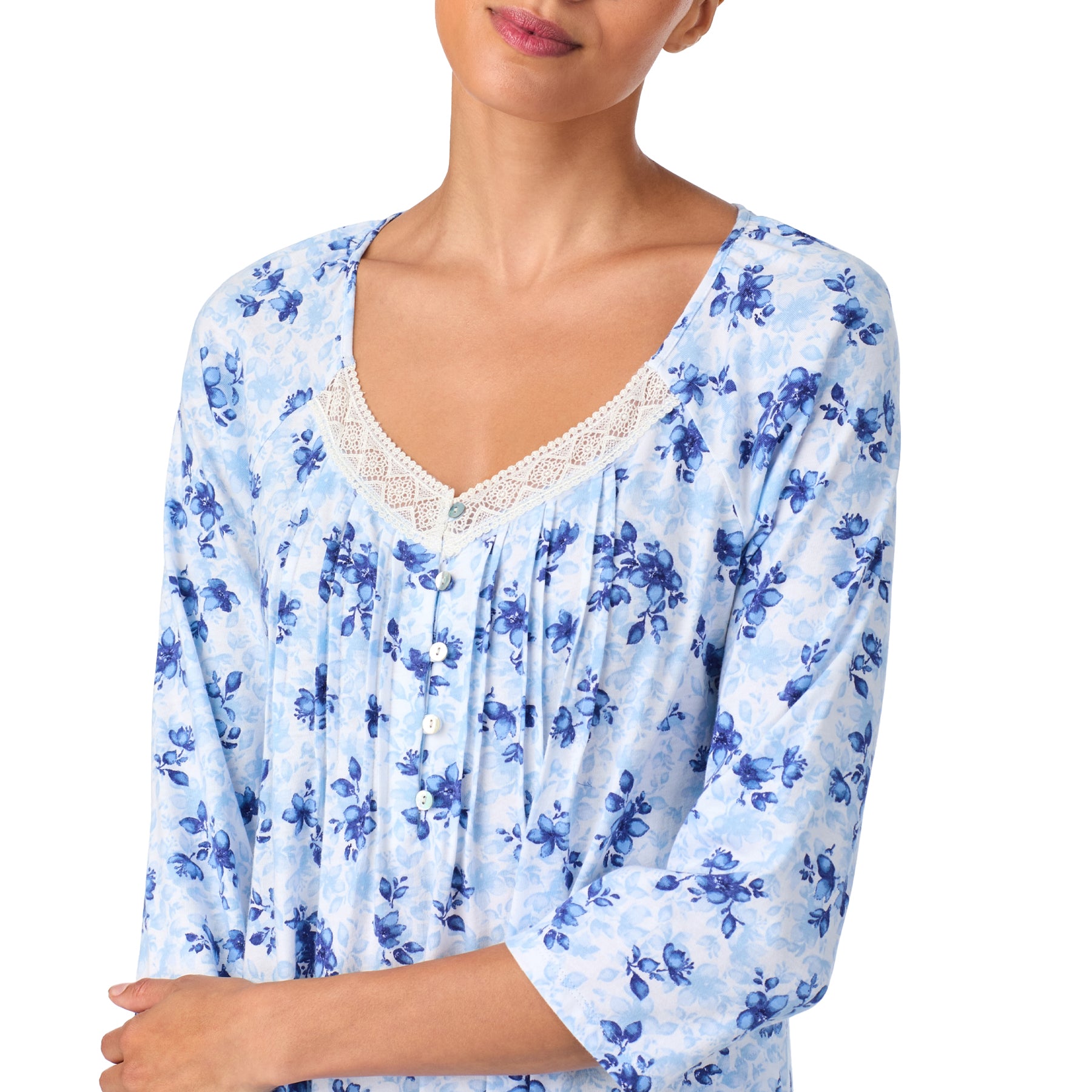 Woman wearing a blue floral blouse with lace trim on a white background