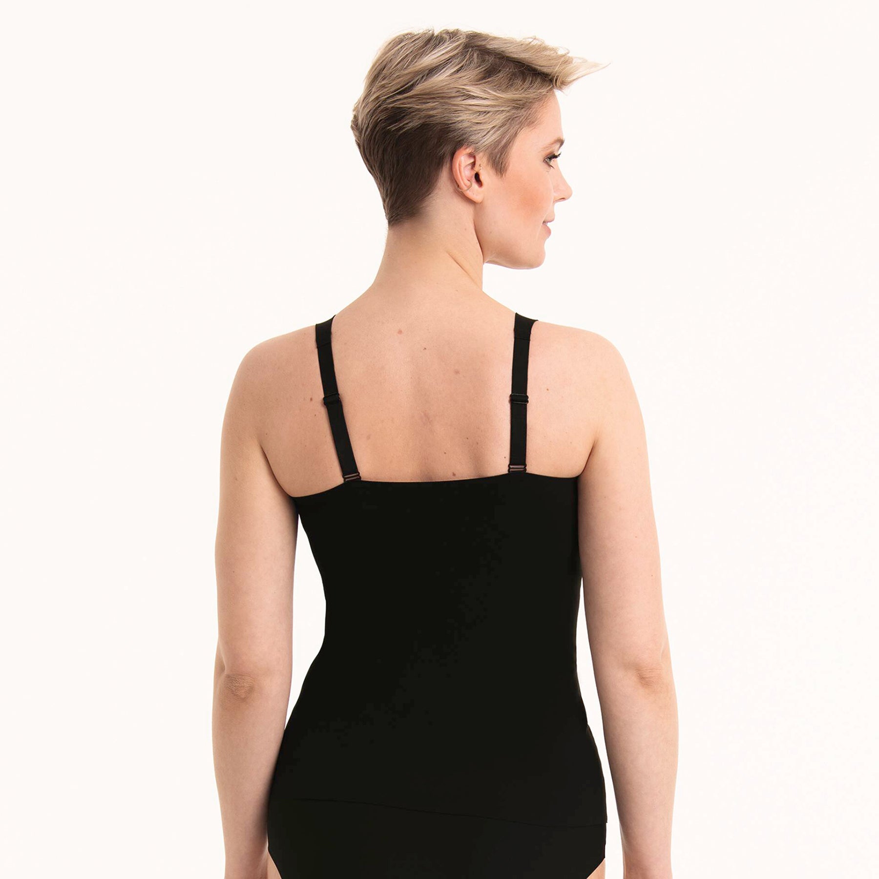 Rear view of woman wearing ANITA 0654 Essential Tank with Shelf Bra in Black, showing smooth back and adjustable straps