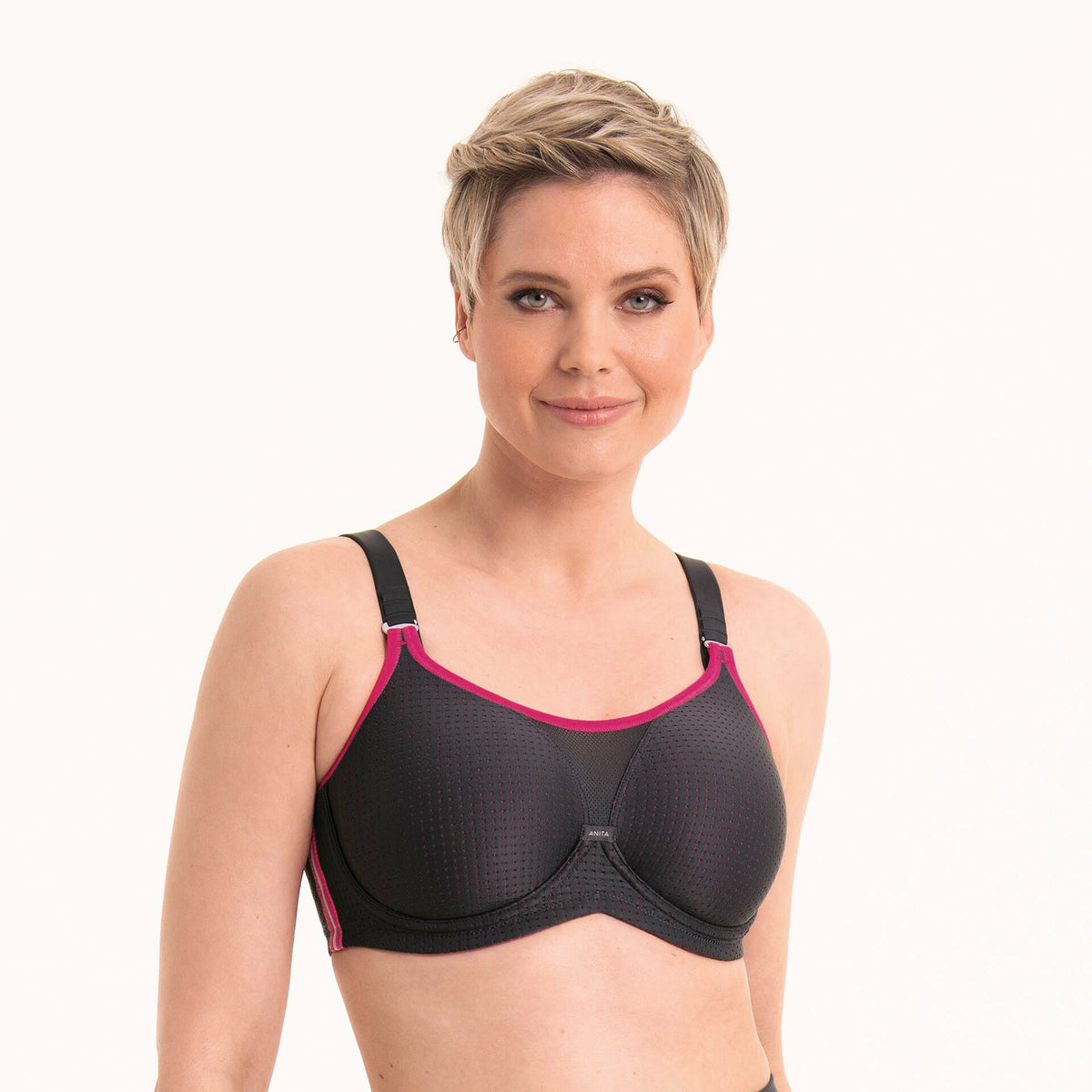 Anita 5599 performance wireX sports bra in 481 anthrazit/pink; a charcoal grey with hot pink trim. Front view on model.