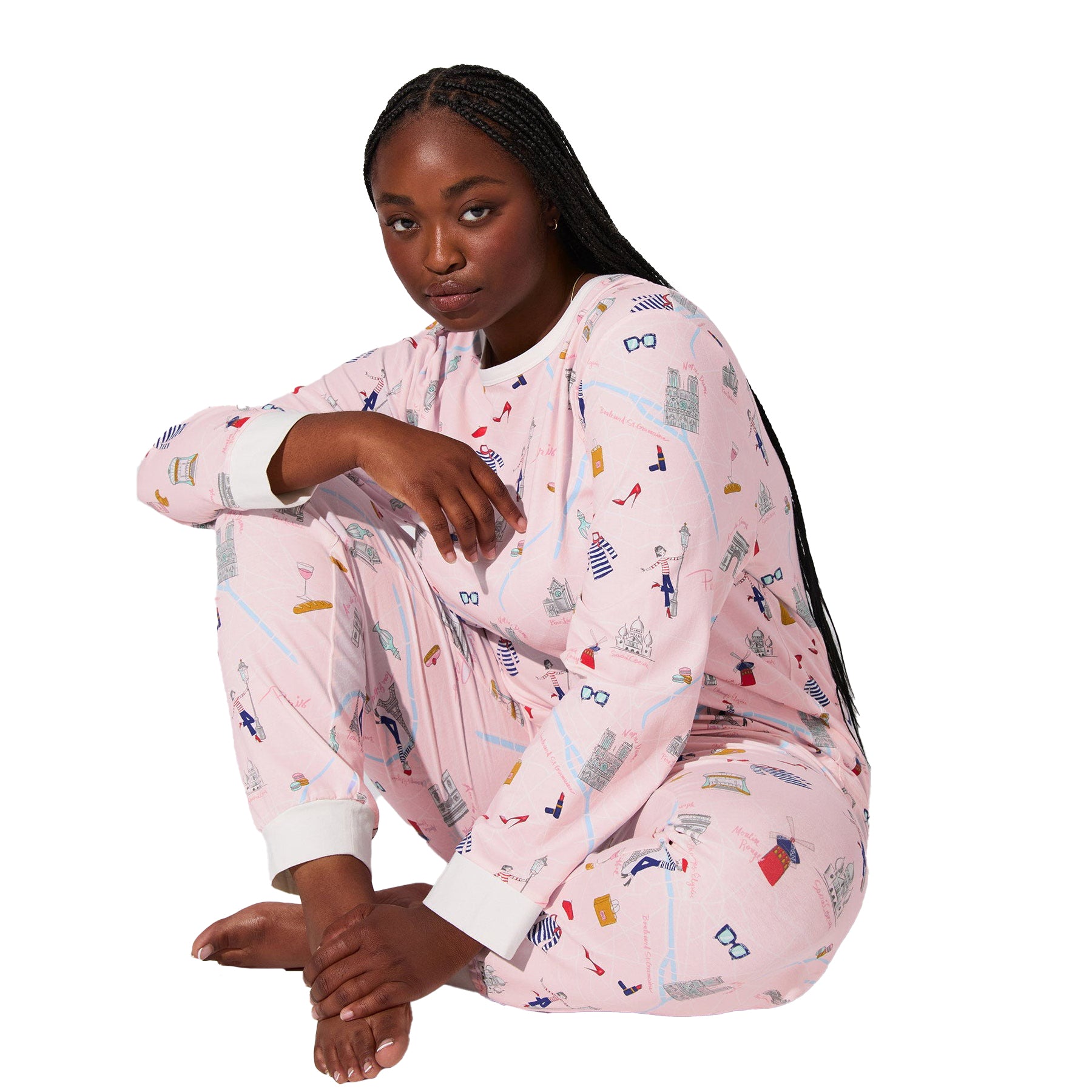 Front seated view of plus-size model wearing pink Paris-themed long-sleeve pajama set with jogger pants and white cuffs.