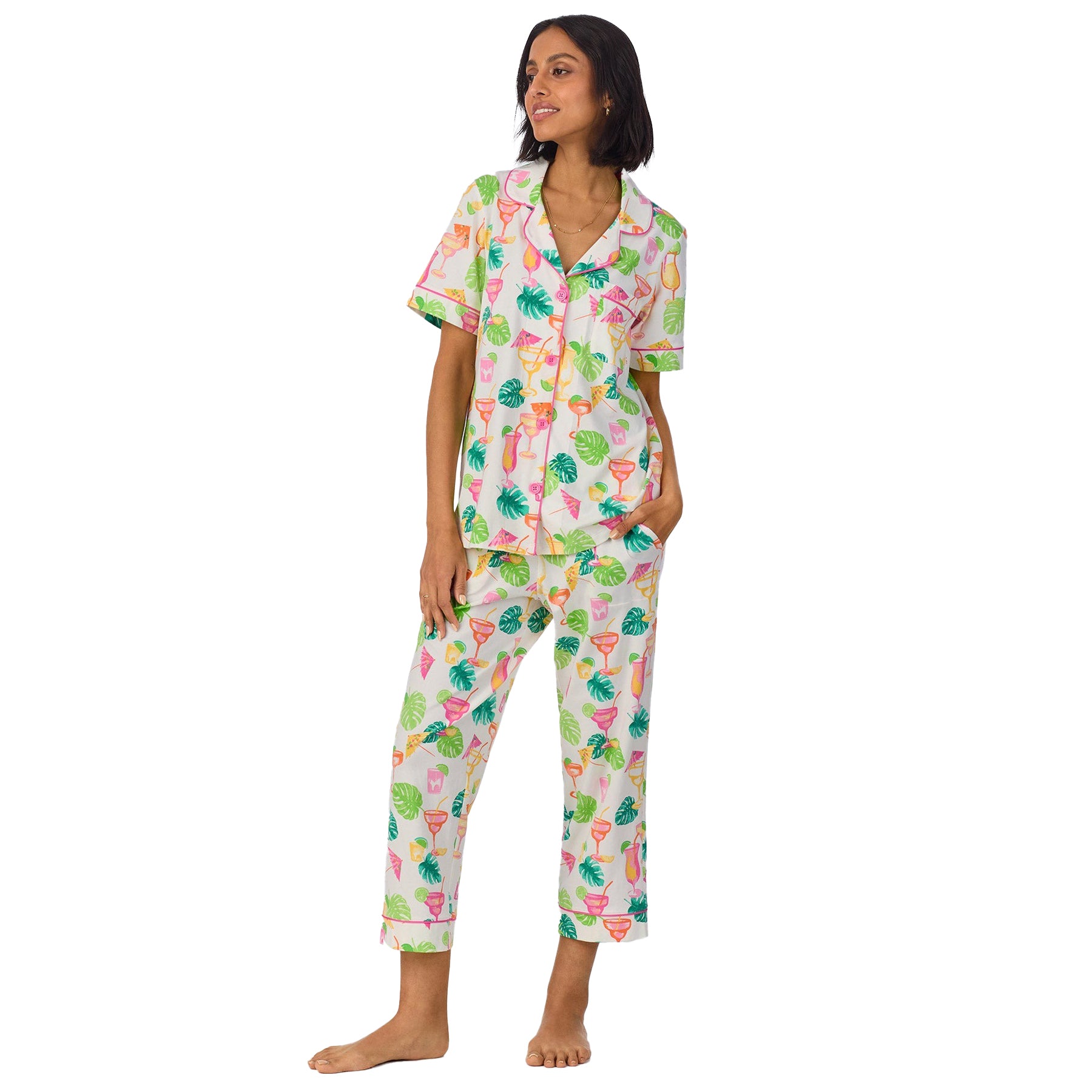 Model standing in a relaxed pose wearing the tropical print pyjama set with a collared button-up top and cropped pants.
