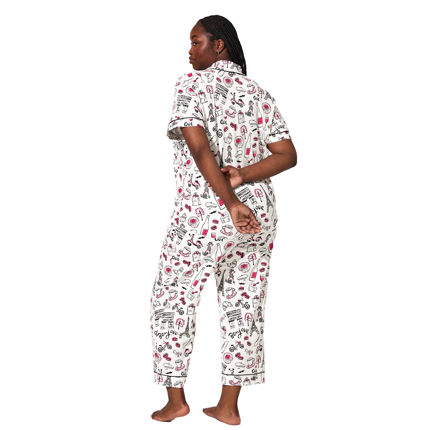 Back view of plus-size model wearing Paris-themed pajama set with cropped pants and black piping trim.