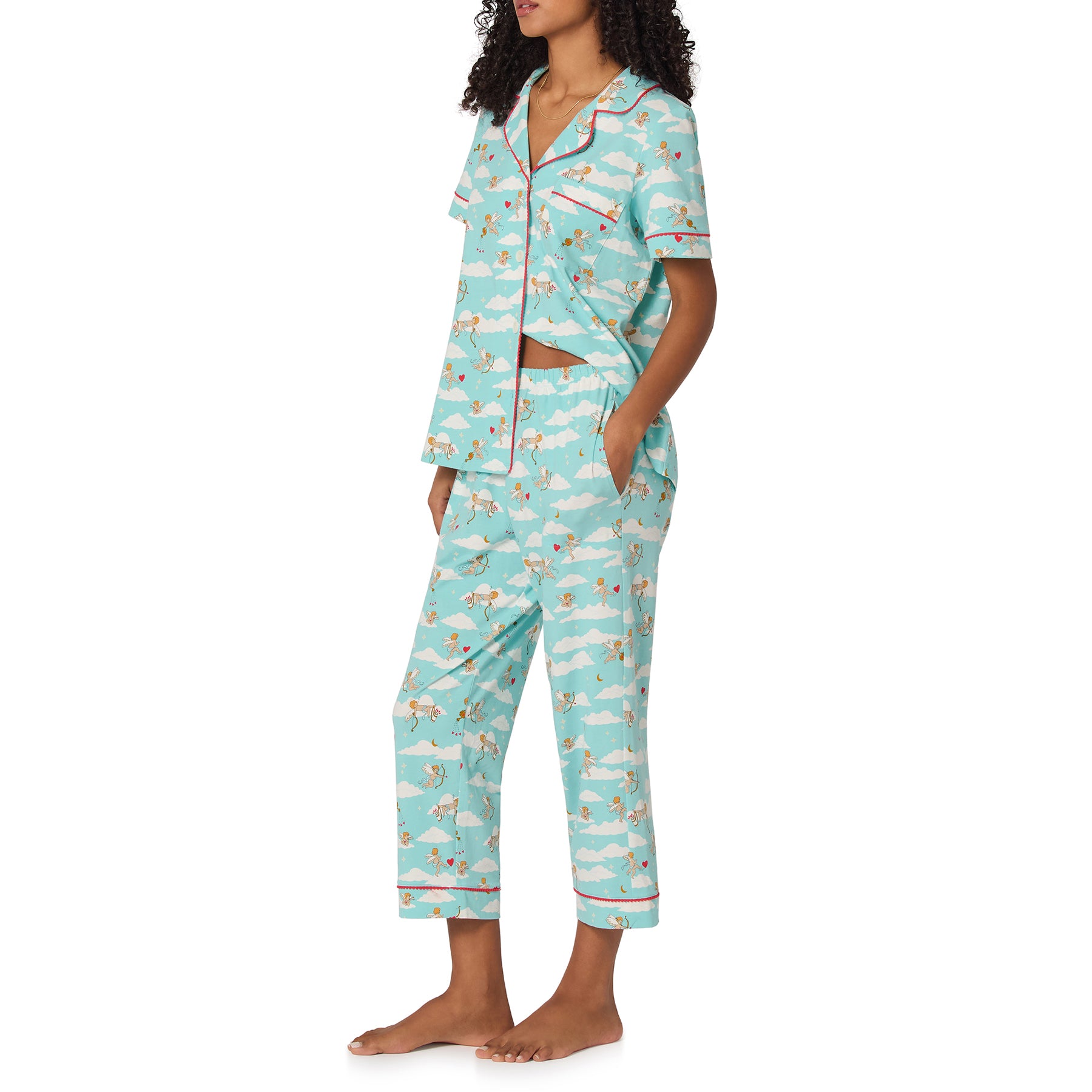Woman wearing a light blue pajama set with cloud and star pattern on a white background