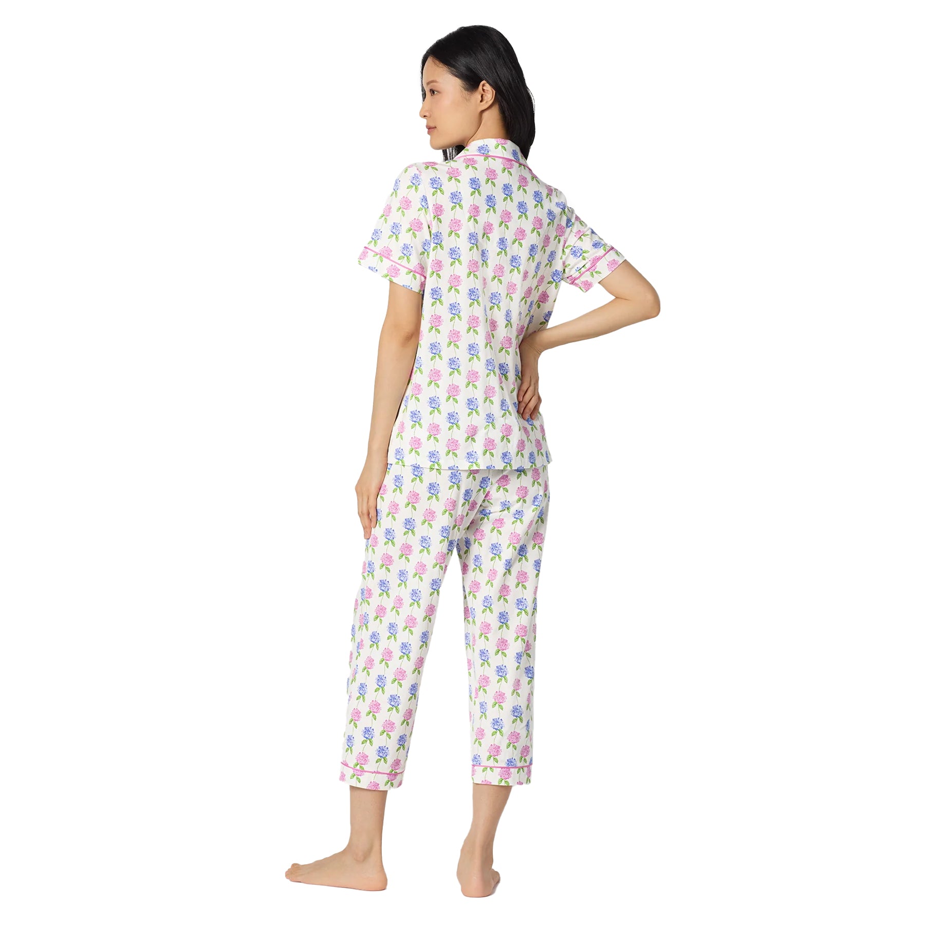 Side back view of a white floral sleepwear set with pastel pink and blue flowers, short sleeve top, and relaxed cropped pants.