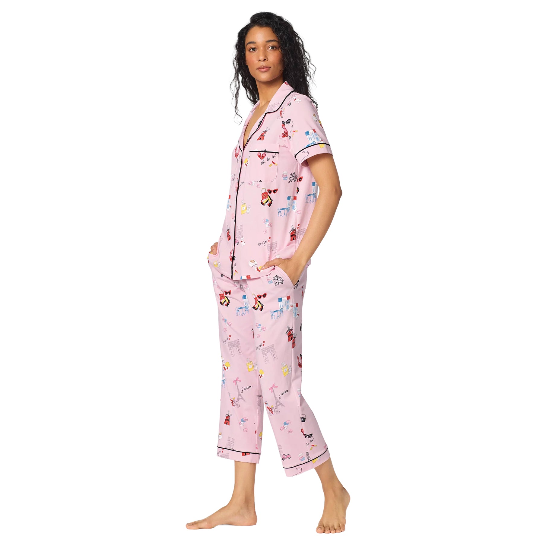 Side view of a pink button-front pajama set with Paris-themed print, short sleeves, cropped pants and black piping.