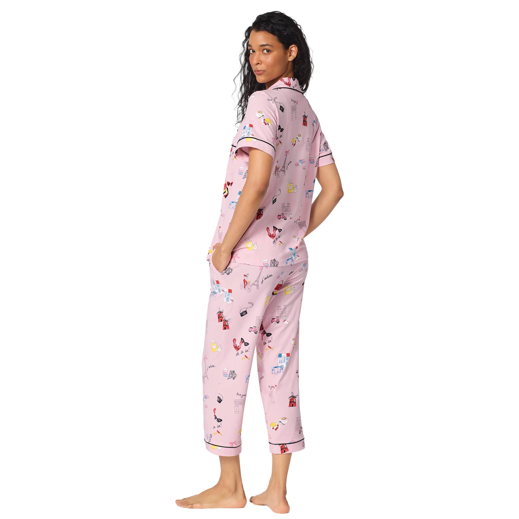 Back view of a pink short-sleeve pajama set with cropped pants, colourful Paris-inspired motifs and black contrast piping.
