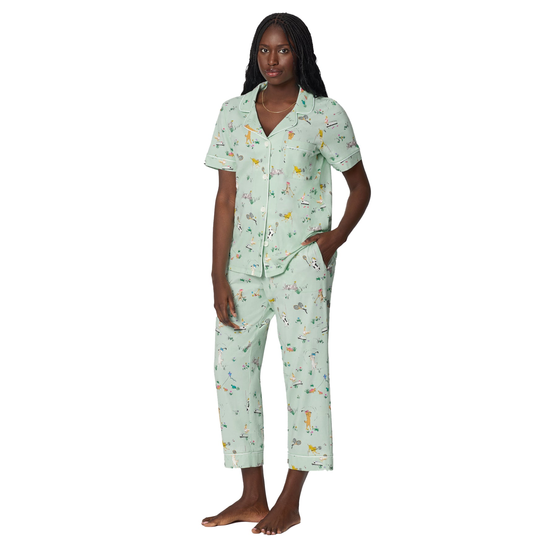 Front view of mint green women’s pajama set with contrast piping, short sleeves and cropped pants in playful tennis dog print.