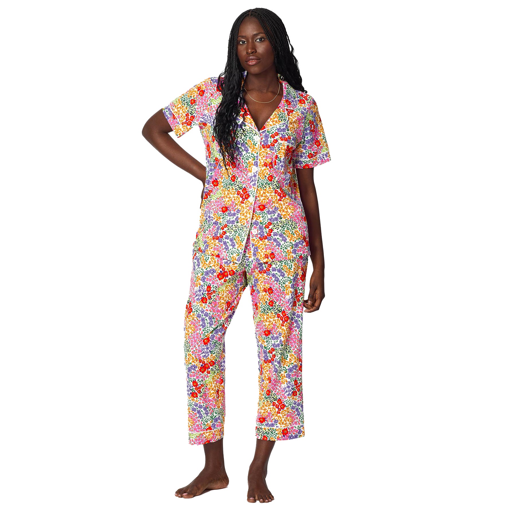 Front view of women’s bright multicolour floral pajama set featuring short sleeve button-down shirt with contrast piping and cropped pants.